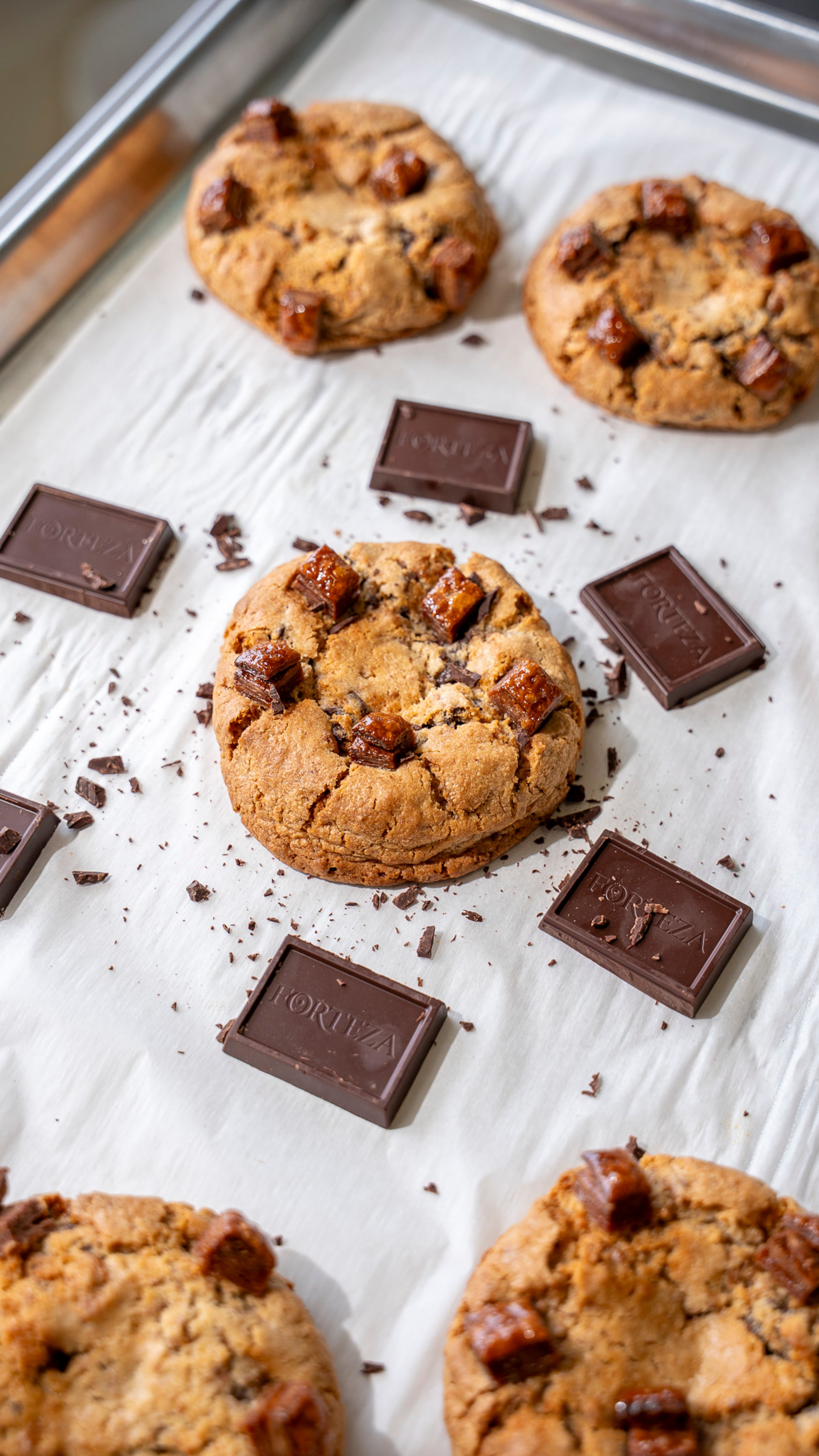 La galleta de Choco Quesito está rellena de chocolate Forteza 50% y queso crema, añadiendo hojaldre de chocolate en la masa y en el top de la galleta.