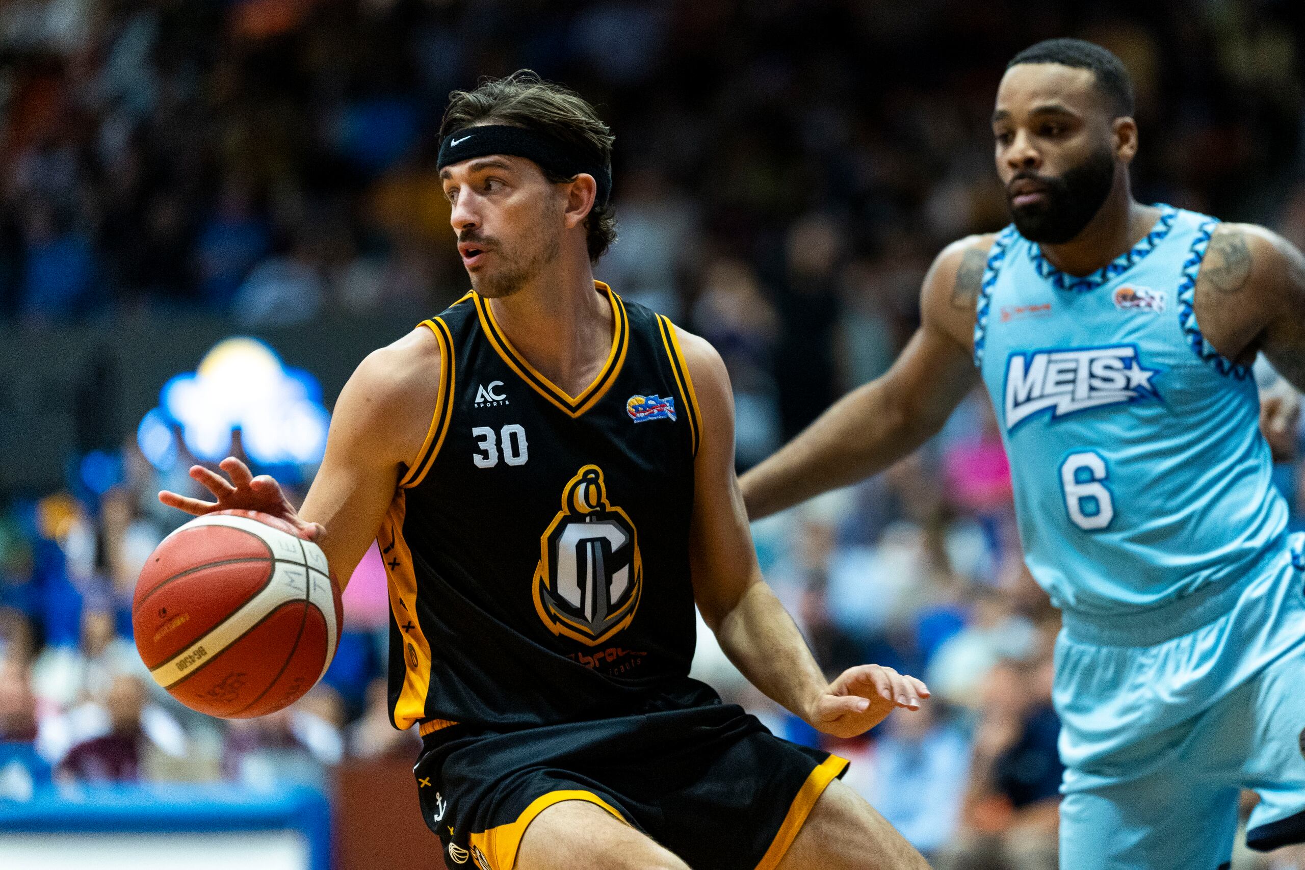 David Stockton (izquierda) maneja el balón ante la defensa de Jaysean Paige.