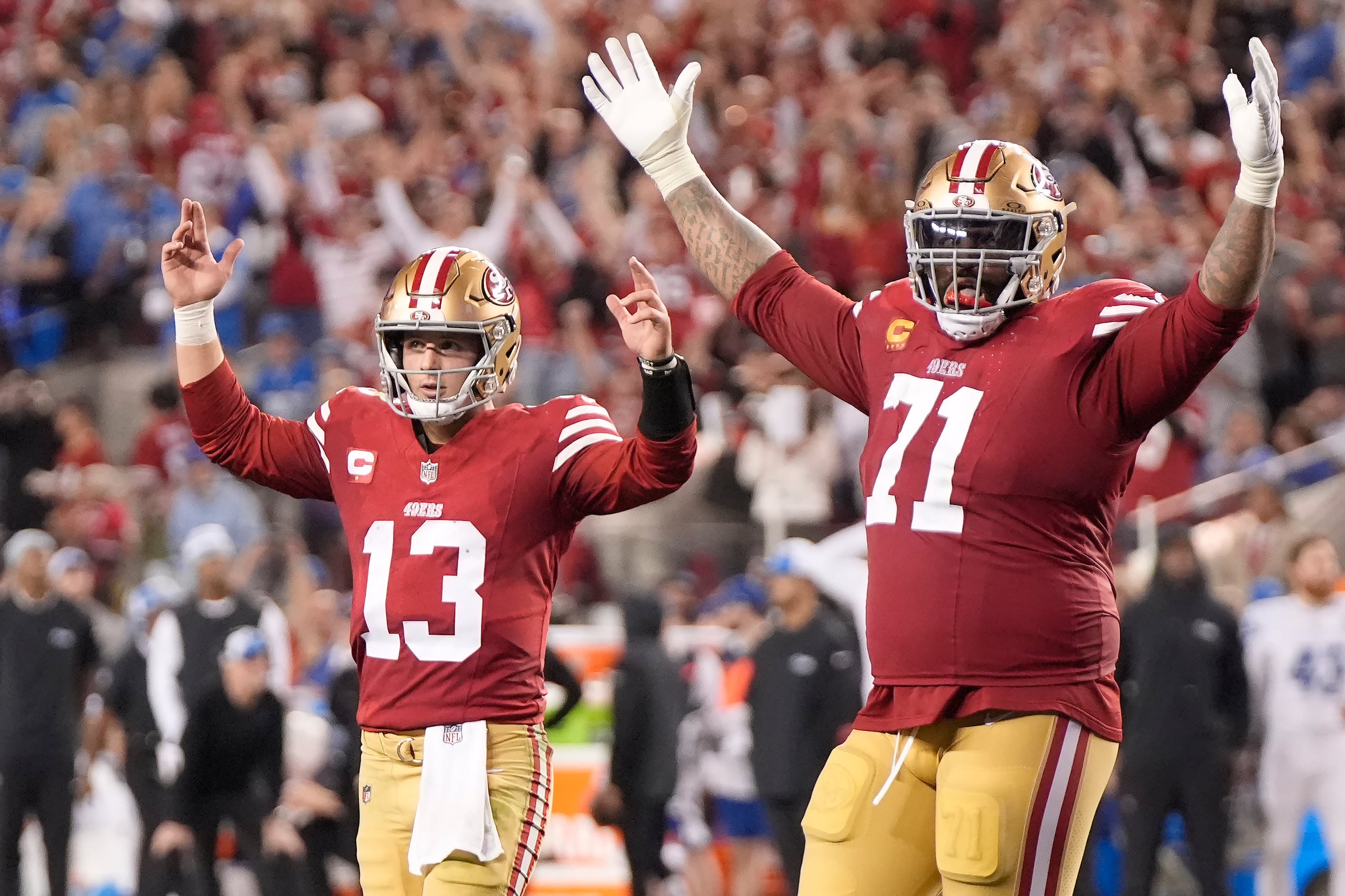 El mariscal de campo de los San Francisco 49ers, Brock Purdy (13) y el tackle ofensivo Trent Williams (71), celebran después de un touchdown de Elijah Mitchell.