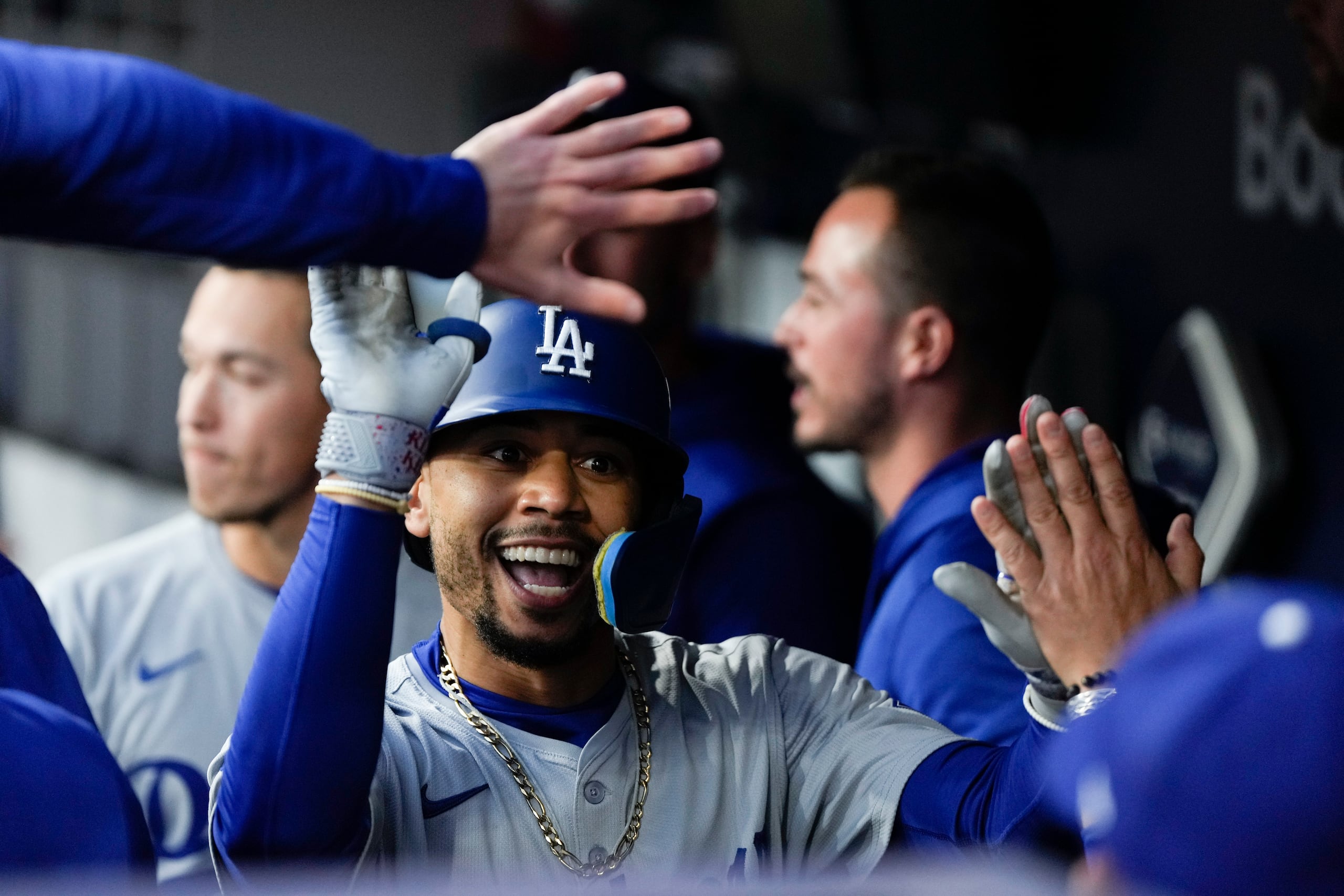 Mookie Betts, de los Dodgers de Los Ángeles, festeja en la cueva luego de conseguir un jonrón en el cuarto juego de la serie divisional de la Liga Nacional ante los Padres de San Diego.