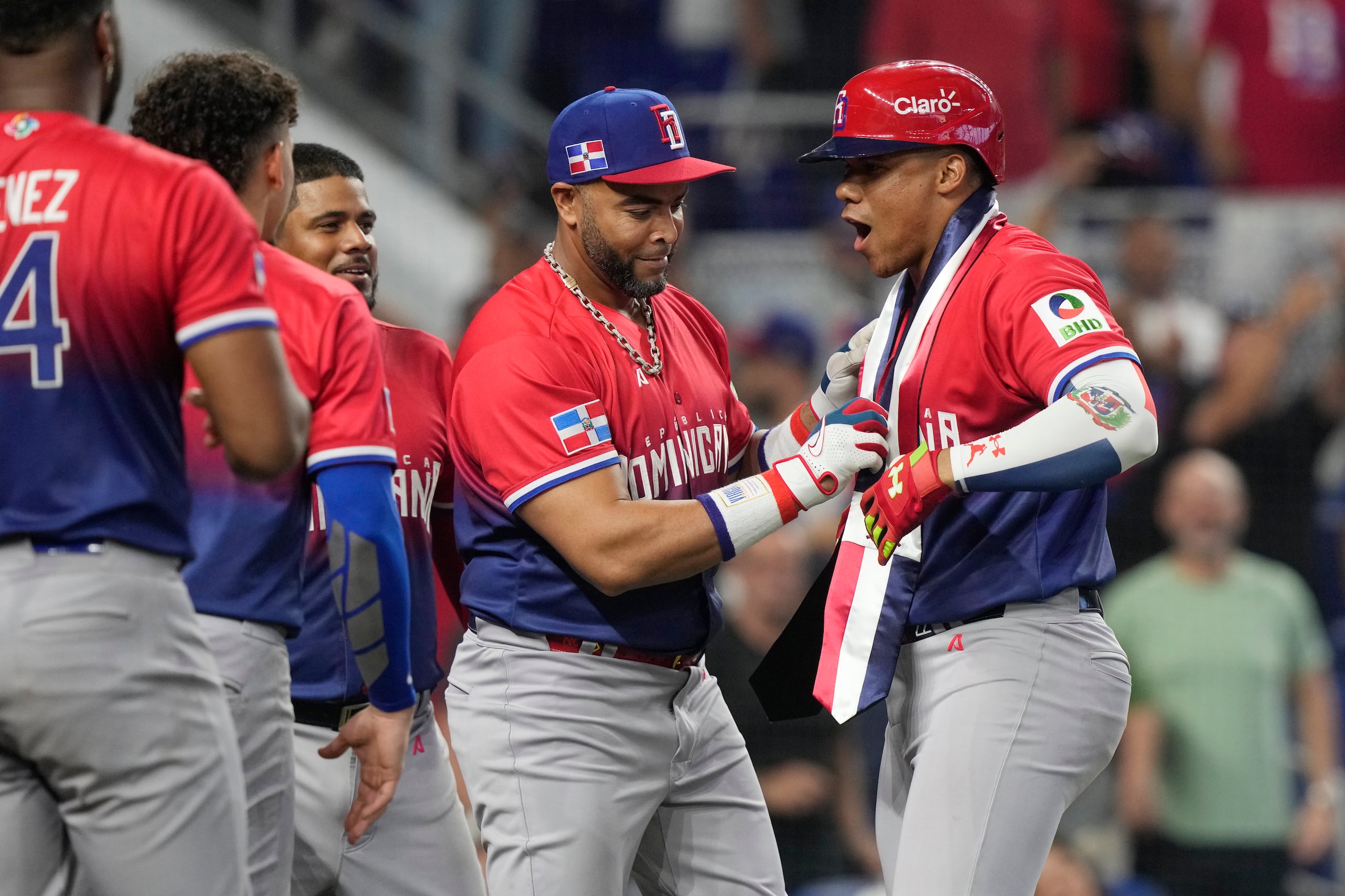 Juan Soto (derecha) de la República Dominicana recibe una banda presidencial de manos de Nelson Cruz reacciona tras disparar un jonrón ante Nicaragua en el Clásico Mundial de Béisbol 2023.