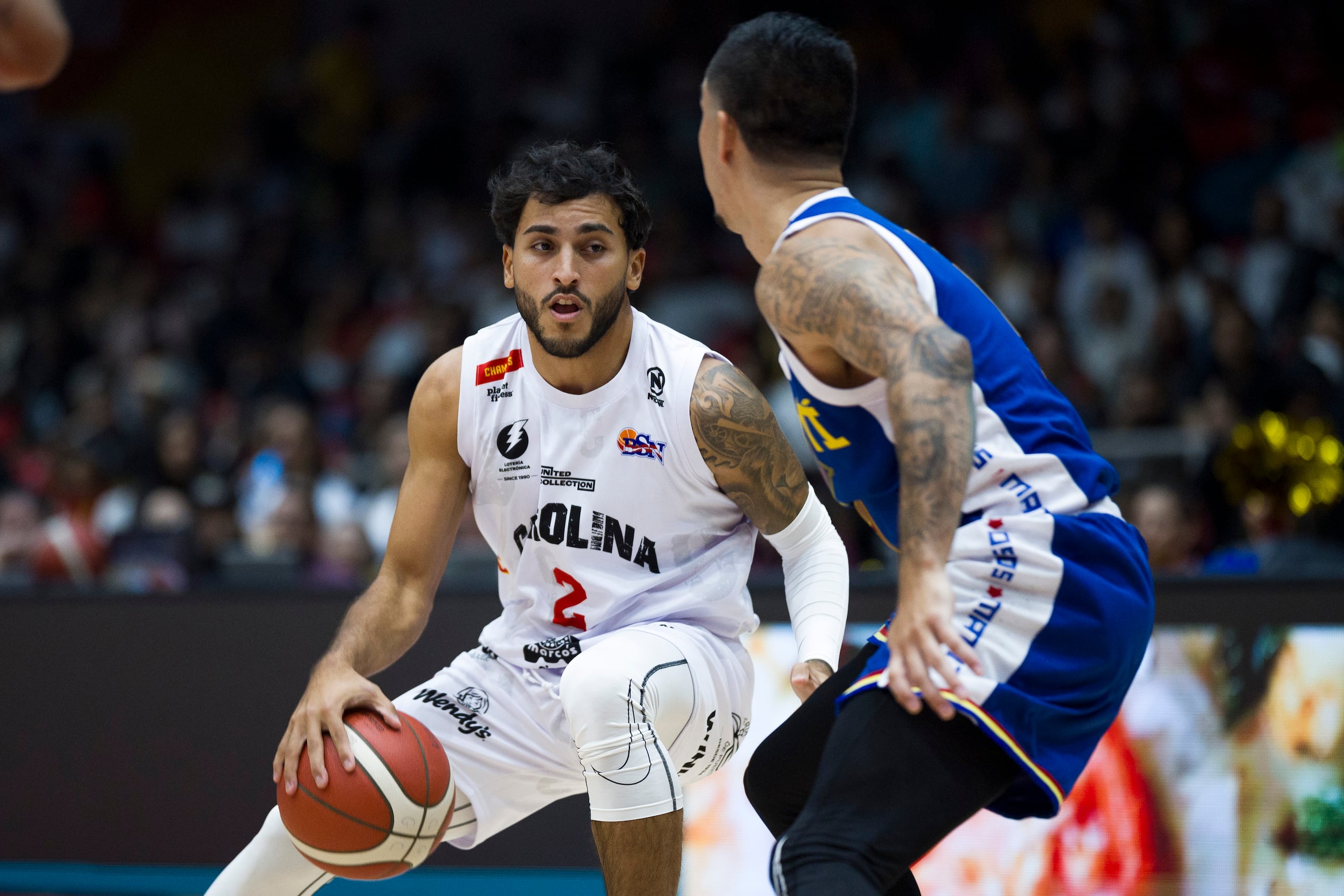 El armador Evander Ortiz controla el balón frente a la defensa de los Osos de Manatí.