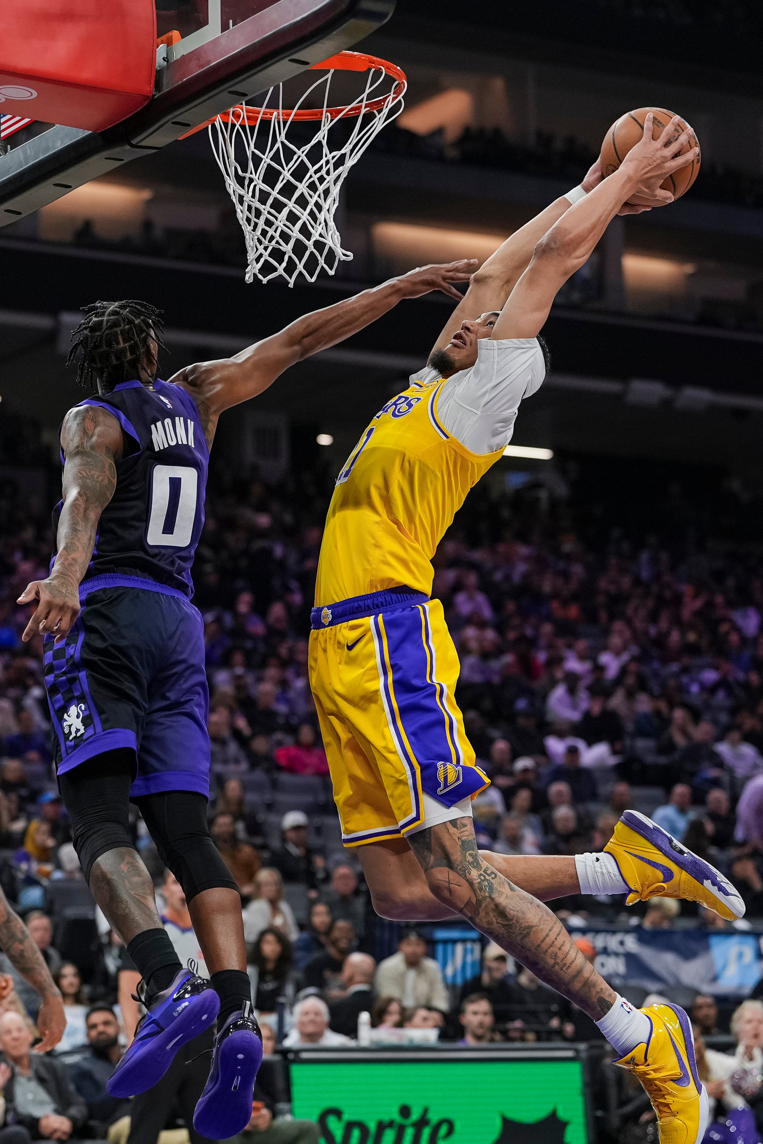 Jaxson Hayes, derecha, de los Lakers de Los Ángeles, se alza para clavar el balón sobre Malik Monk (0), de los Kings de Sacramento, durante la primera mitad del juego de baloncesto de la NBA, el lunes 12 de enero de 2026, en Sacramento, California. (AP Foto/Justine Willard)