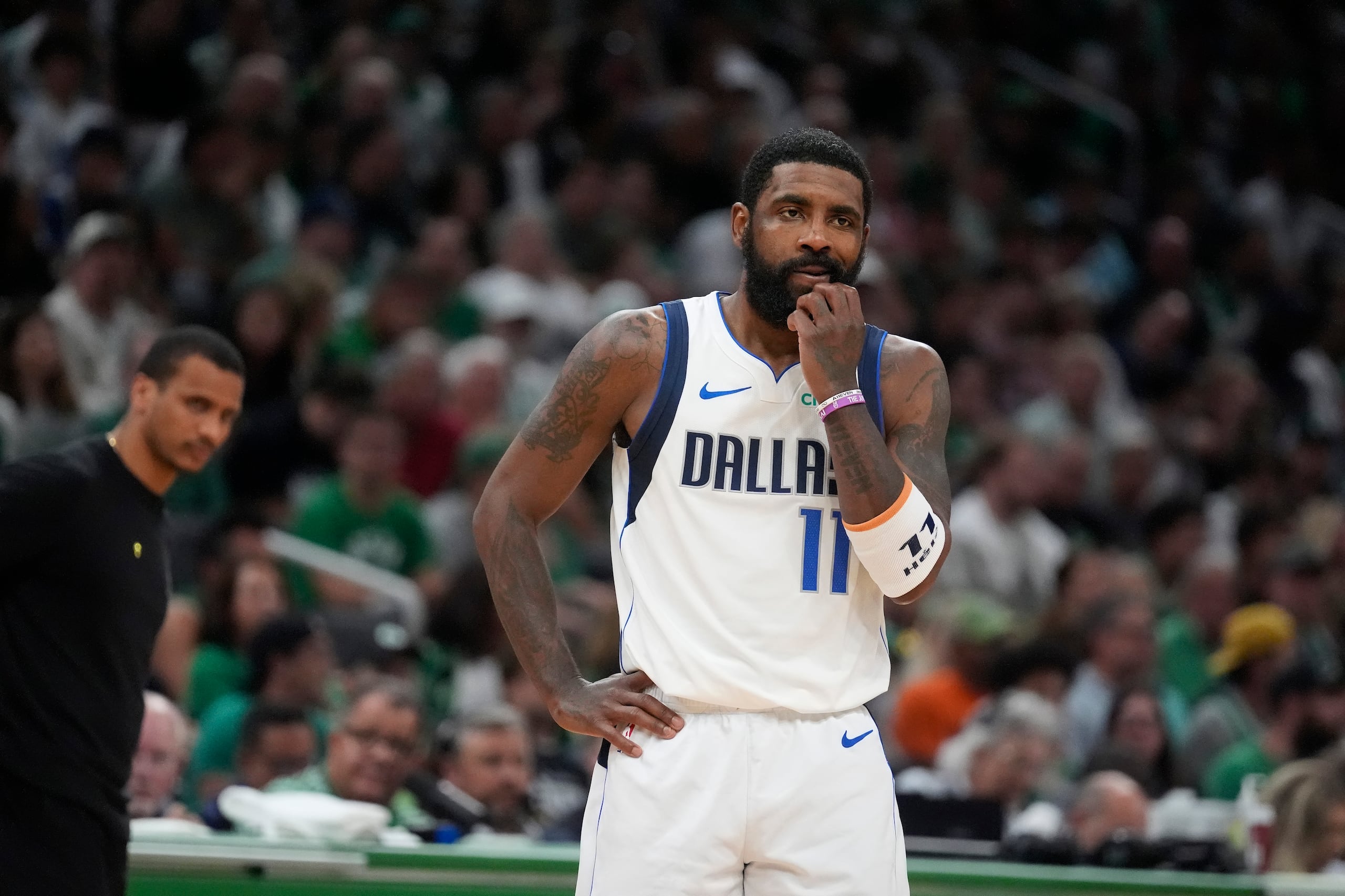 El armador de los Mavericks de Dallas, Kyrie Irvinng, se detiene en la cancha frente al entrenador de los Celtics de Boston, Joe Mazzulla.