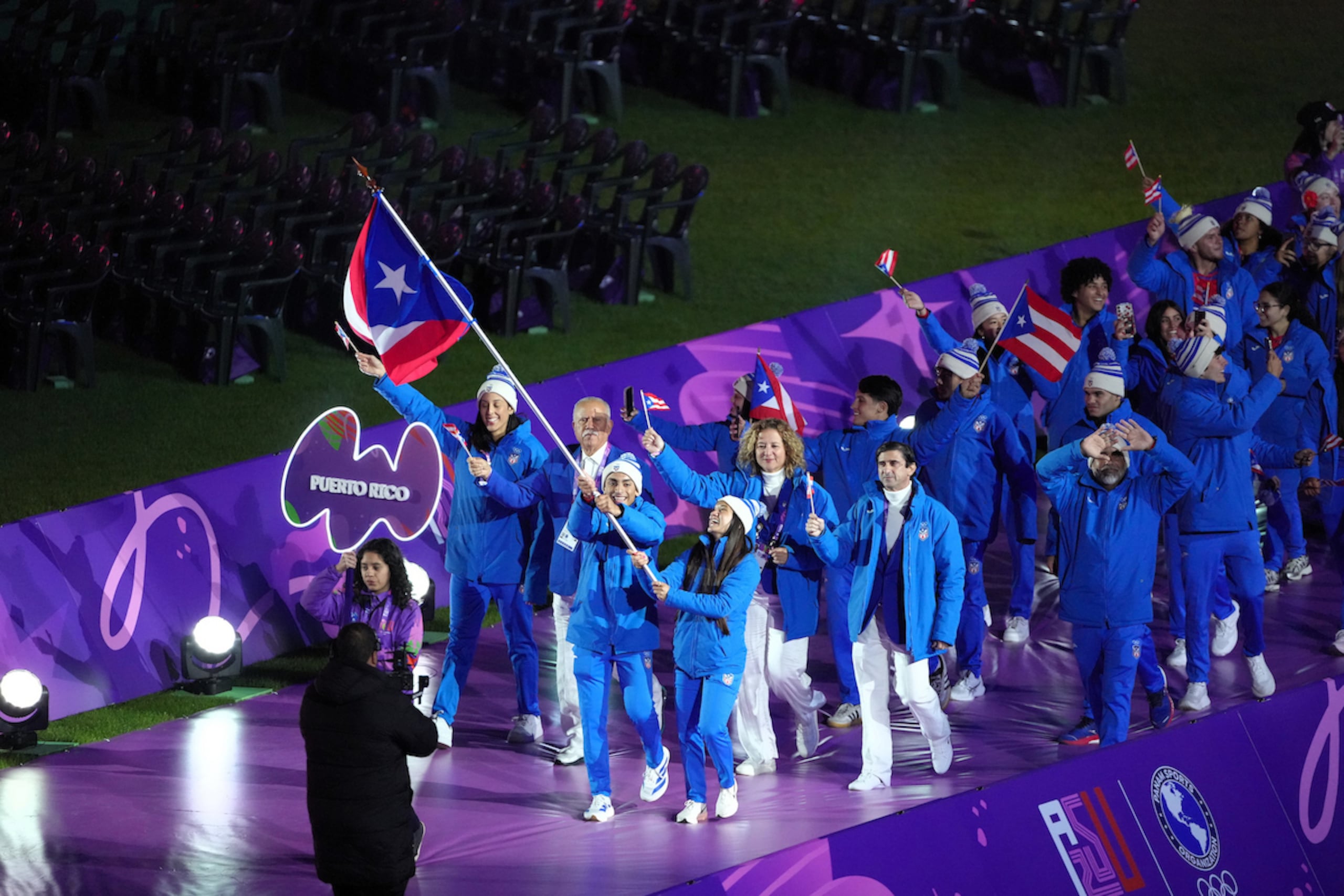 La delegación de Puerto Rico, con Steven Moreno y Gladymar Torres cargando la bandera, hace su entrada al estadio en los actos inaugurales de los II Juegos Panamericanos Junior. (Luis Licona / Staffon Images)