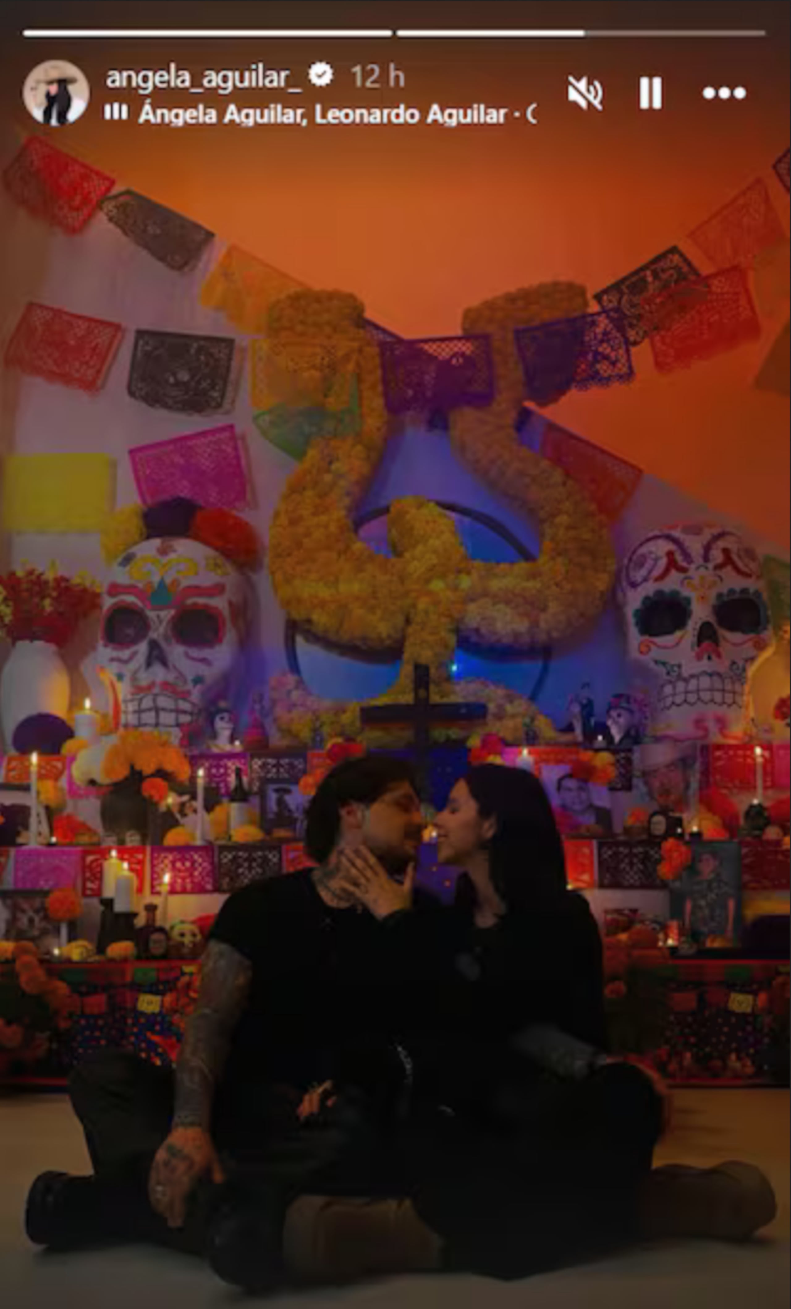 Ángela Aguilar compartió en sus historias de Instagram este retrato en el que besa a Christian Nodal frente al altar familiar dedicado a sus abuelos, Antonio Aguilar y Flor Silvestre.