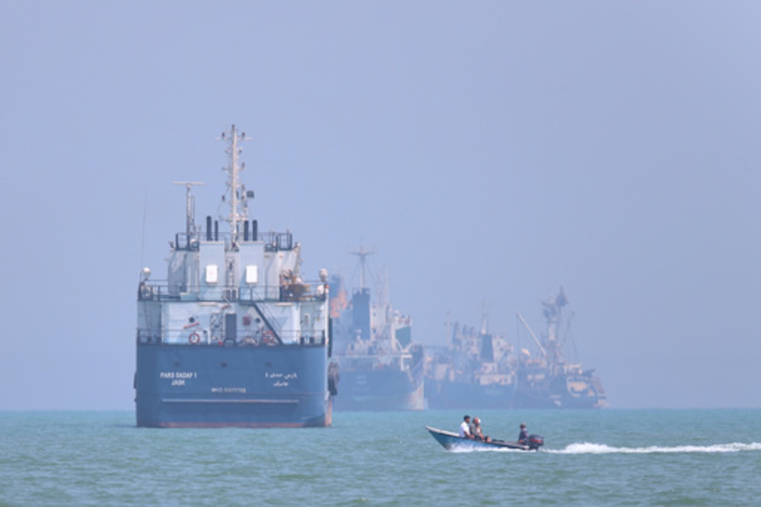 Una pequeña lancha a motor pasa junto a unos barcos fondeados en el estrecho de Ormuz, frente a Bandar Abbas (Irán), el jueves 11 de junio de 2026. (Amirhosein Khorgooi/ISNA vía AP)