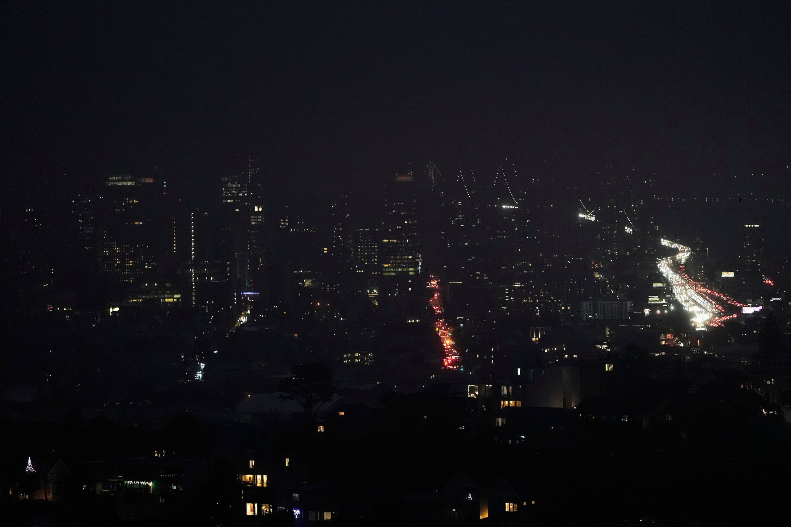 La niebla y los cortes de electricidad oscurecen el horizonte mientras el tráfico circula por San Francisco, el sábado 20 de diciembre de 2025.. (AP Photo/Jeff Chiu)