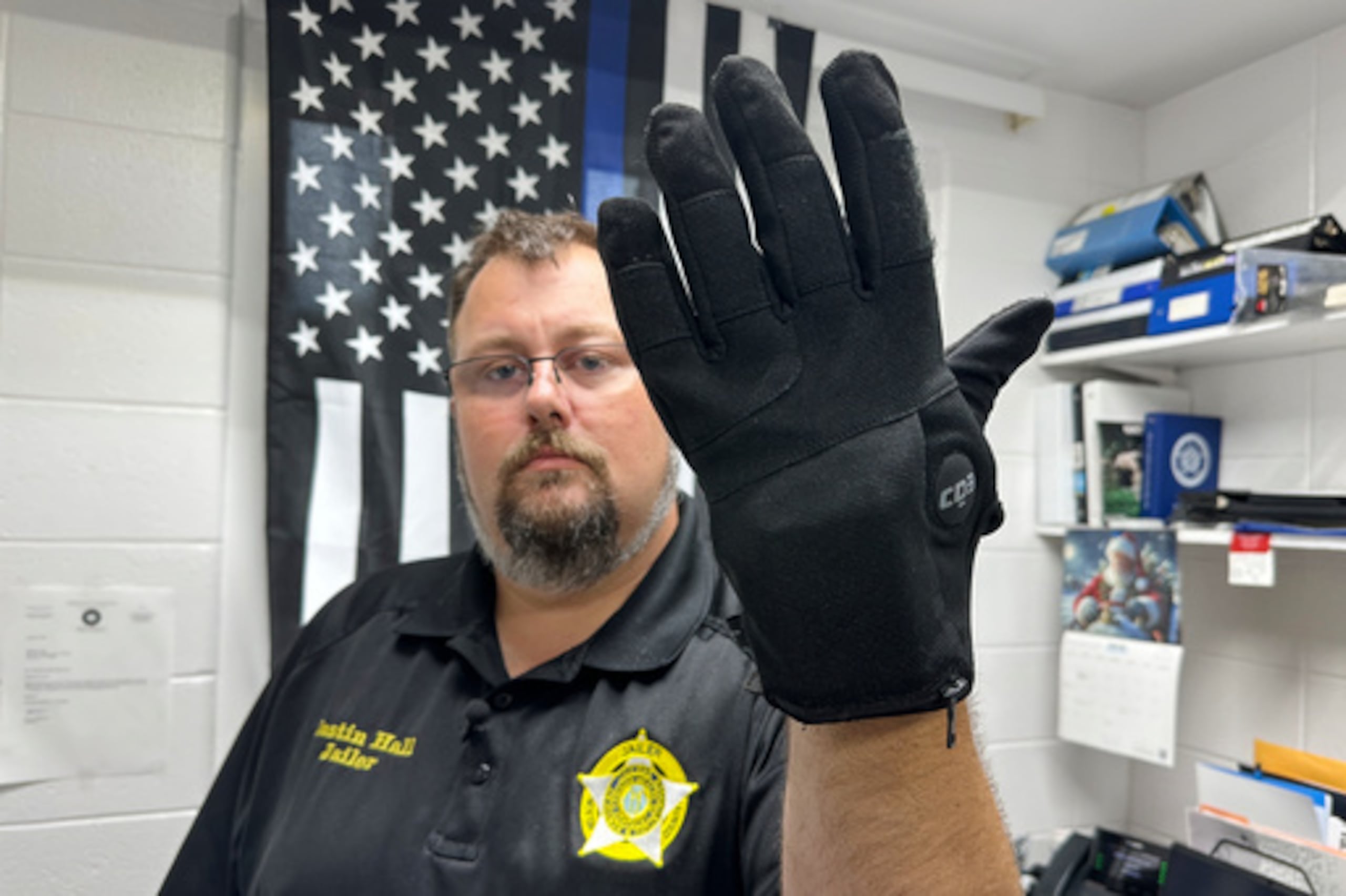 Justin Hall, guardia de la cárcel del condado de Nelson (Kentucky), muestra un guante de descargas eléctricas que se utiliza en su centro, el jueves 13 de agosto de 2026, en Bardstown (Kentucky). (Foto AP/Dylan Lovan)