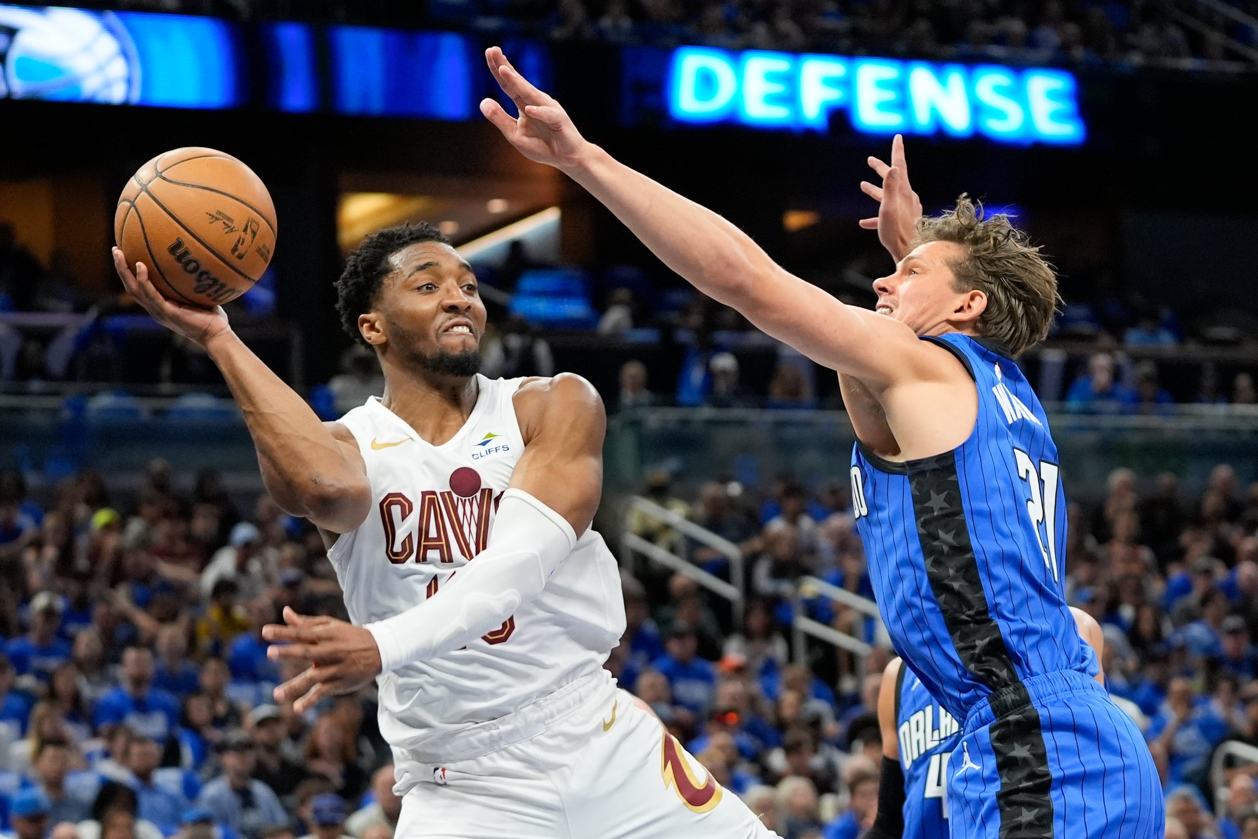 El armador de los Cavaliers de Cleveland Donovan Mitchell (izquierda) pasa el balón ante el pívot del Magic de Orlando Moritz Wagner durante la primera mitad del Juego 4 de la serie de primera ronda de playoffs de la NBA, el sábado 27 de abril de 2024, en Orlando, Florida.