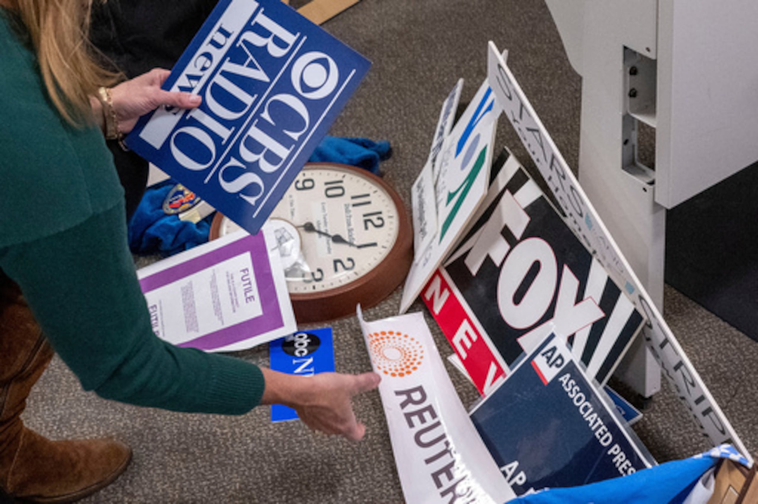 ARCHIVO - La reportera del Washington Post Tara Copp guarda las placas con los nombres de varias organizaciones de noticias mientras ella y los miembros de los medios de comunicación recogen sus pertenencias en la zona de prensa del Pentágono, el 15 de octubre de 2025 en Washington. (AP Photo/Kevin Wolf, Archivo)