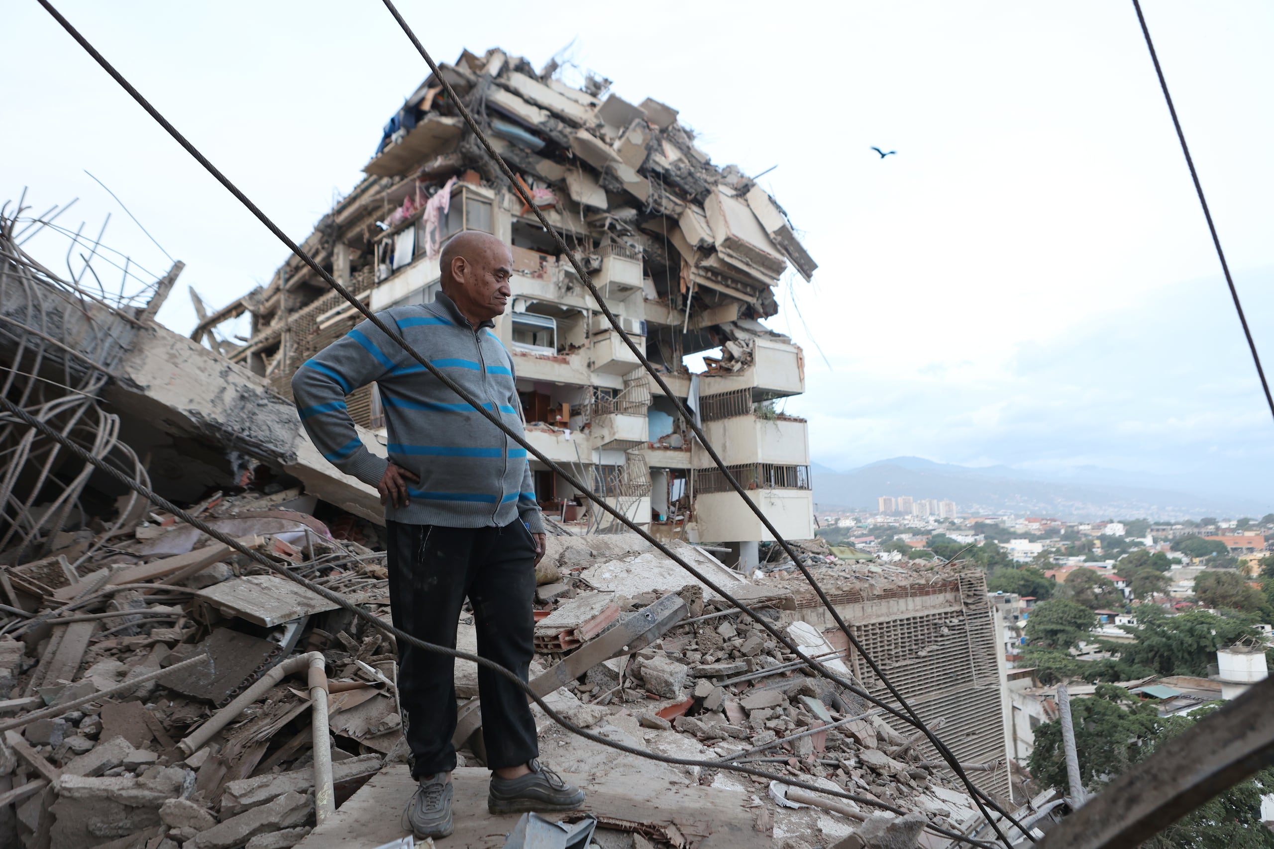 Un hombre permanece de pie entre los escombros de un edificio derrumbado tras un terremoto en La Guaira, Venezuela, el jueves 25 de junio de 2026. (AP Foto/Pedro Mattey)