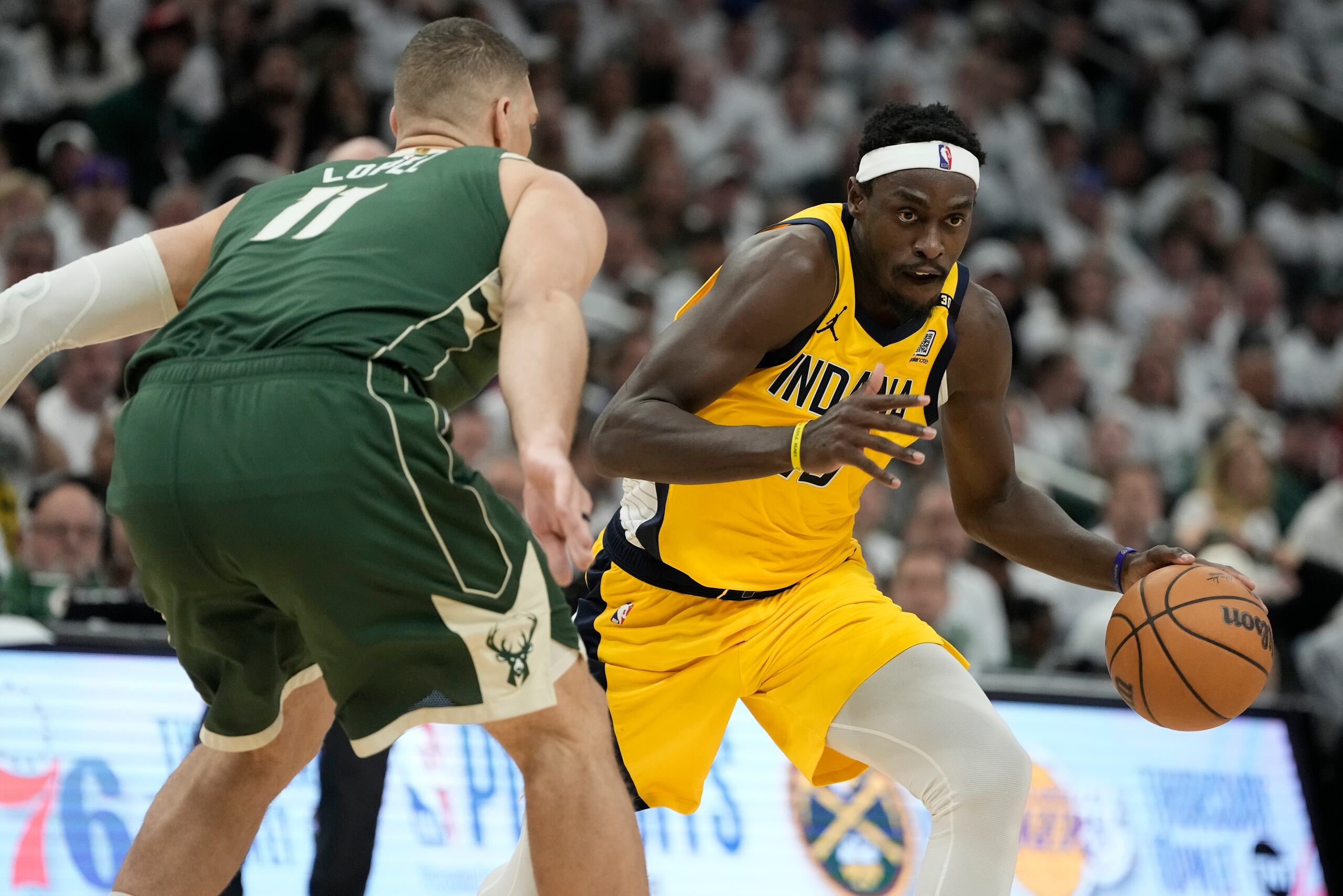Pascal Siakam, de los Pacers de Indiana, trata de atacar el canasto ante Brook López, de los Bucks de Milwaukee.