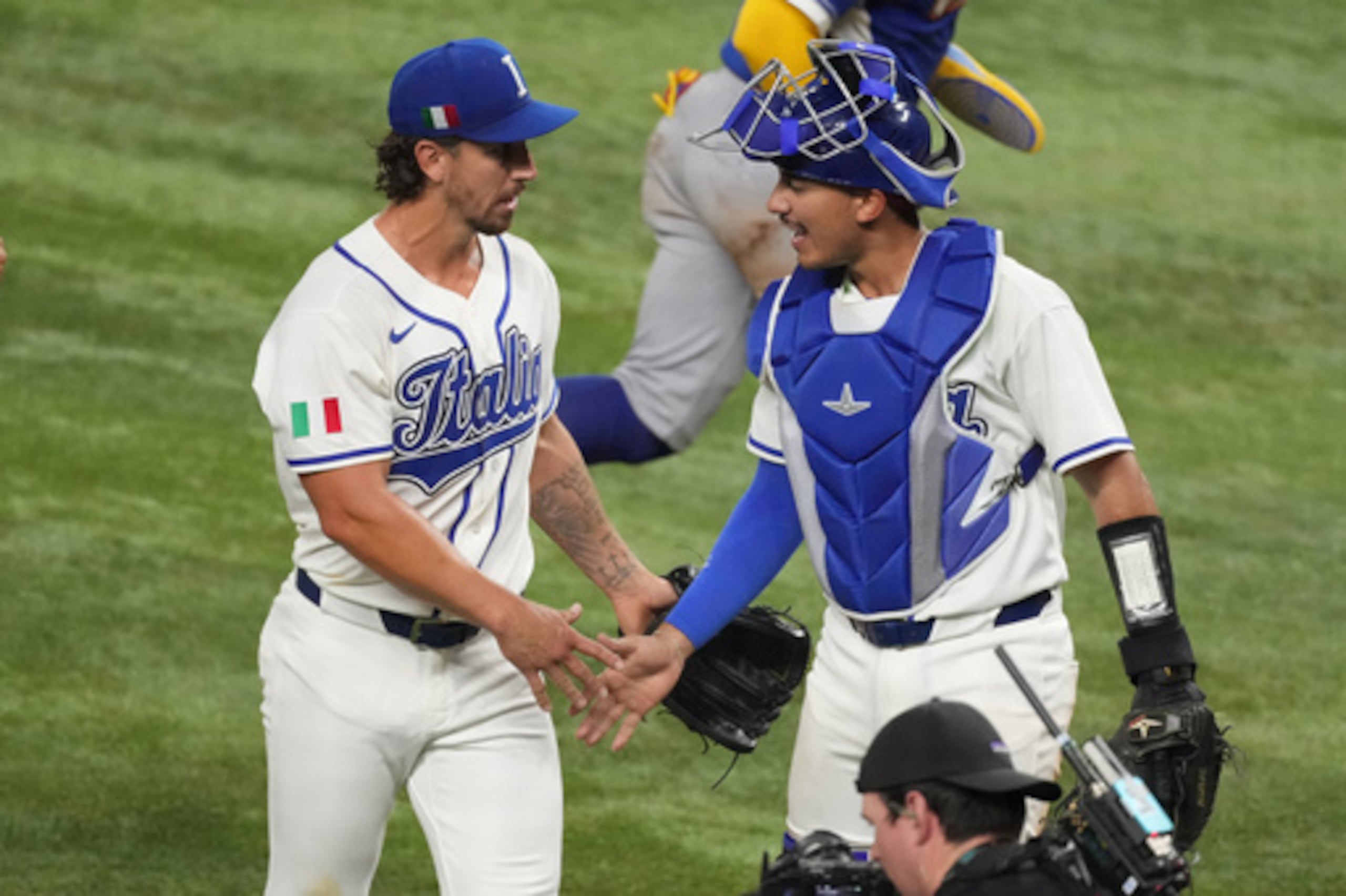 El lanzador italiano Michael Lorenzen y el receptor JJ D'Orazio se dan la mano durante la quinta entrada de un partido de semifinales del Clásico Mundial de Béisbol contra Venezuela, el lunes 16 de marzo de 2026, en Miami. (AP Photo/Lynne Sladky)