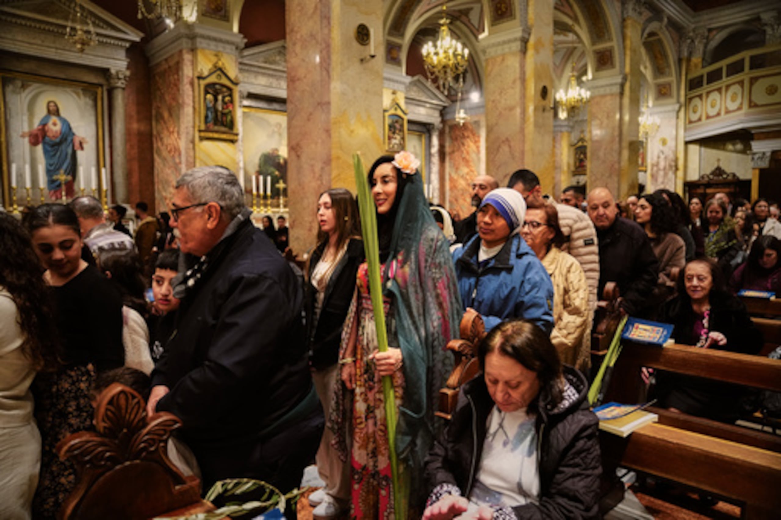 Fieles católicos asisten a una misa de Domingo de Ramos en el Monasterio de San Salvador en la Ciudad Vieja de Jerusalén el domingo 29 de marzo de 2026. (AP Photo/Mahmoud Illean)