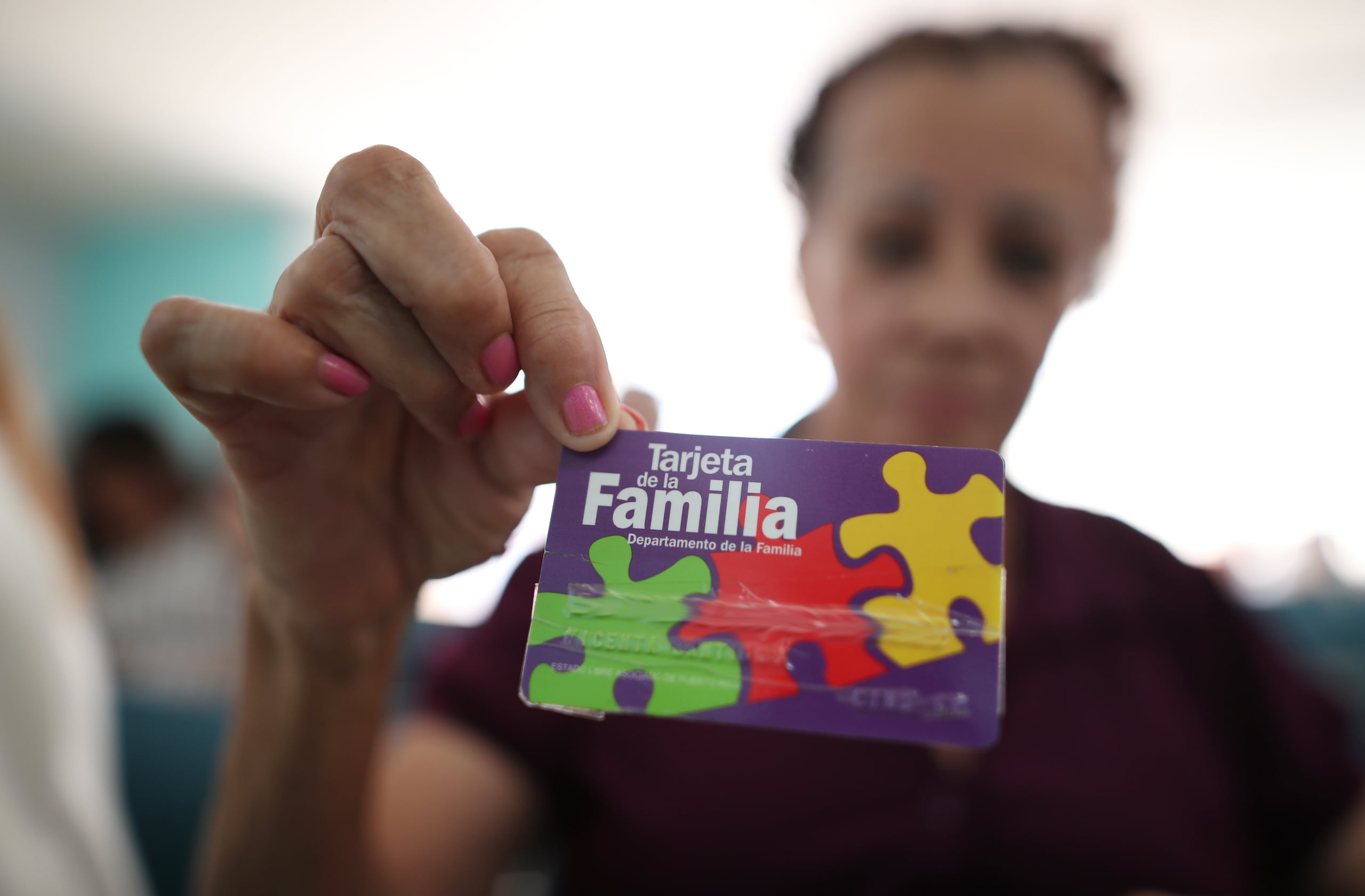 Una de las beneficiarias del PAN muestra su tarjeta electrónica. (Archivo / GFR Media)