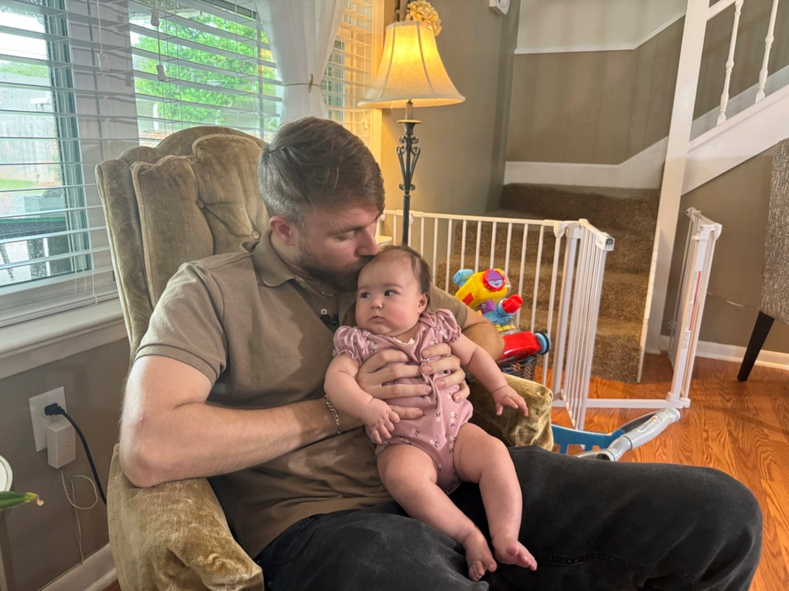 Adrian Clouatre sostiene a su hija de tres meses, Lyn, en su hogar en Baton Rouge, Luisiana.