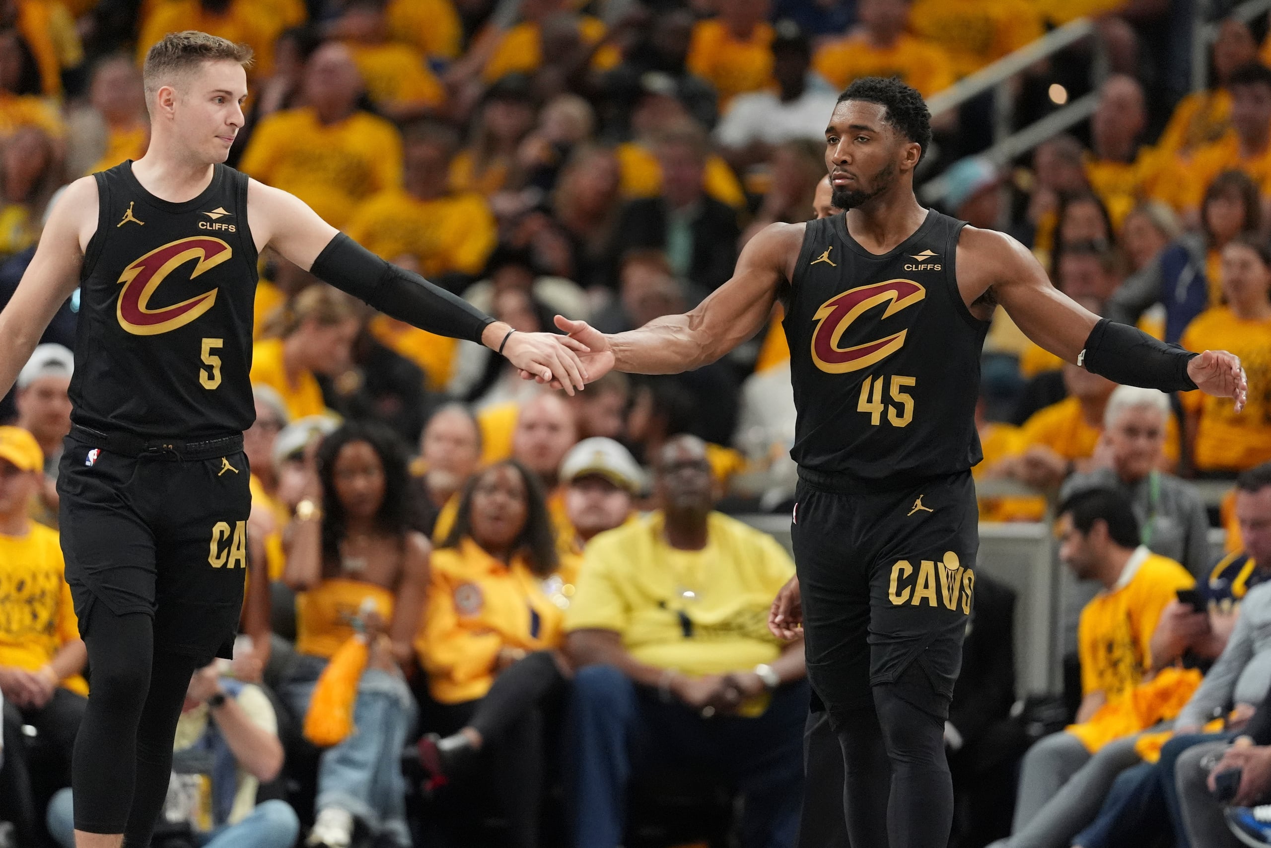 Sam Merrill (5) y Donovan Mitchell (45), de los Cavaliers de Cleveland, festejan en el tercer partido de la semifinal de la Conferencia Este ante los Pacers de Indiana, el viernes 9 de mayo de 2025 (AP Foto/Michael Conroy)