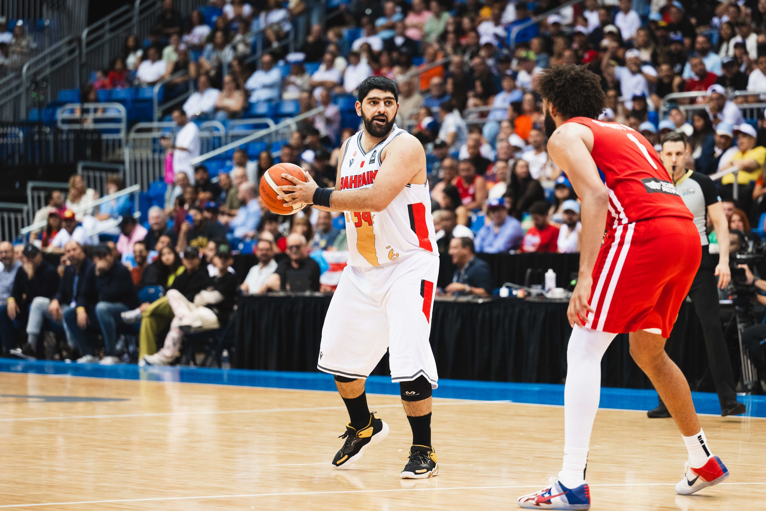 Ali Hasan (izquierda) busca a quien pasar el balón durante el partido de Baréin contra Puerto Rico.