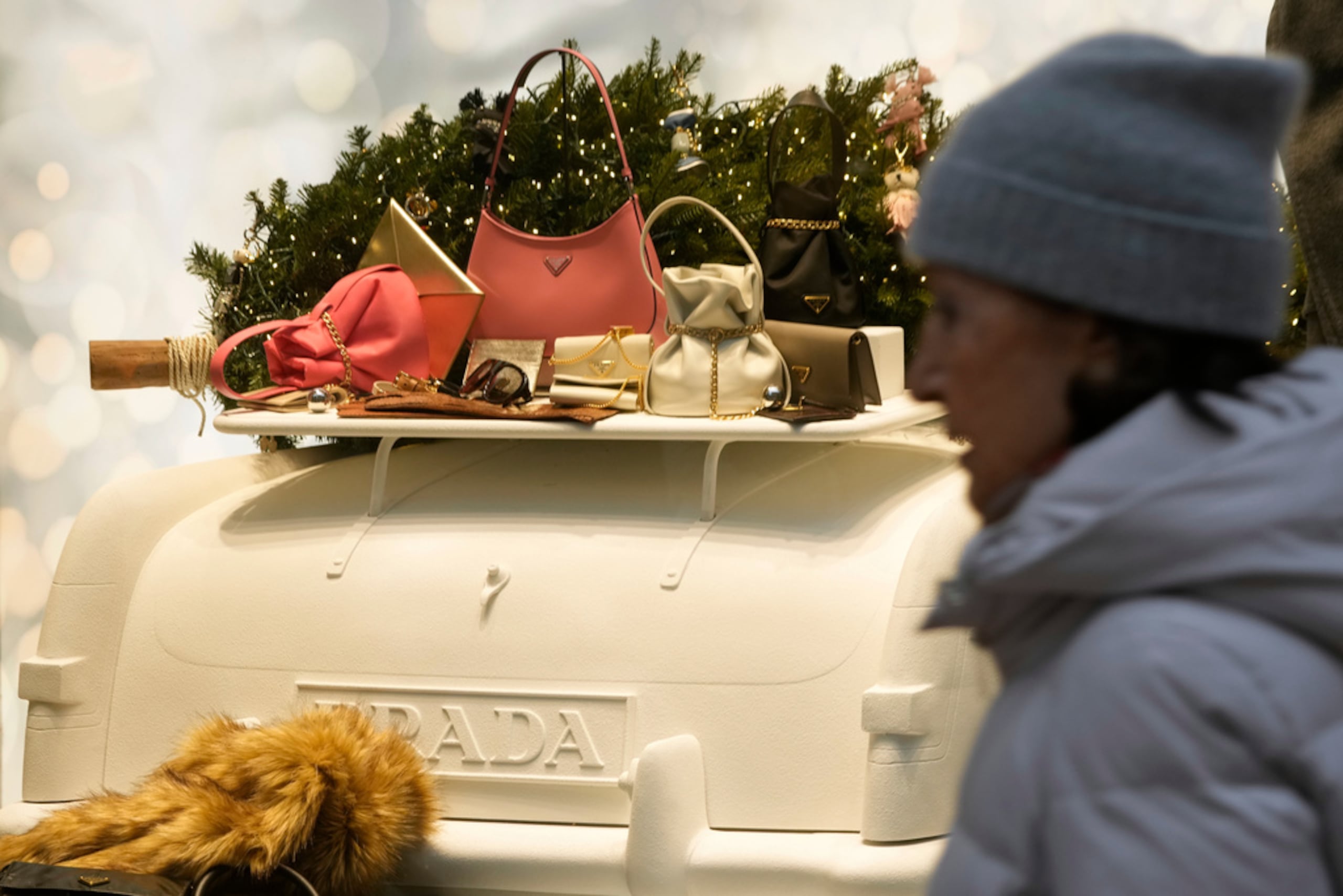 Una mujer camina junto a un escaparate de Prada, en Milán, Italia, el martes 2 de diciembre de 2025.