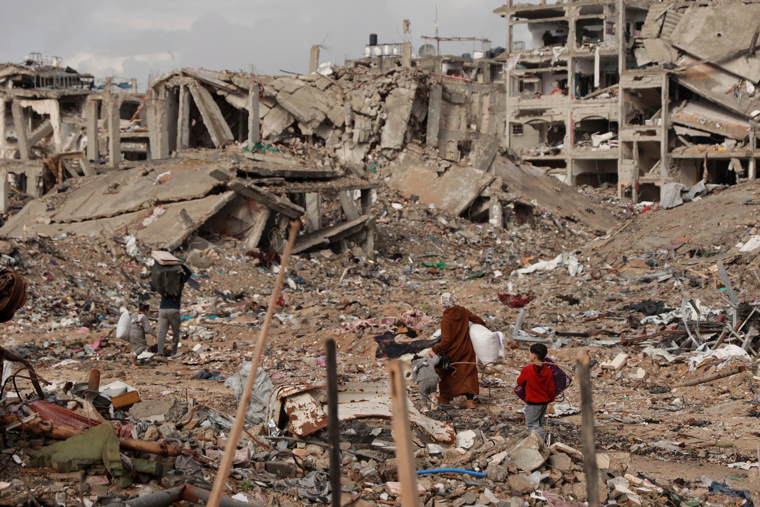 Palestinos caminan entre los escombros de viviendas destruidas luego de un cese al fuego acordado entre Israel y Hamás, en Ciudad de Gaza, en la Franja de Gaza, el viernes 24 de enero de 2025.