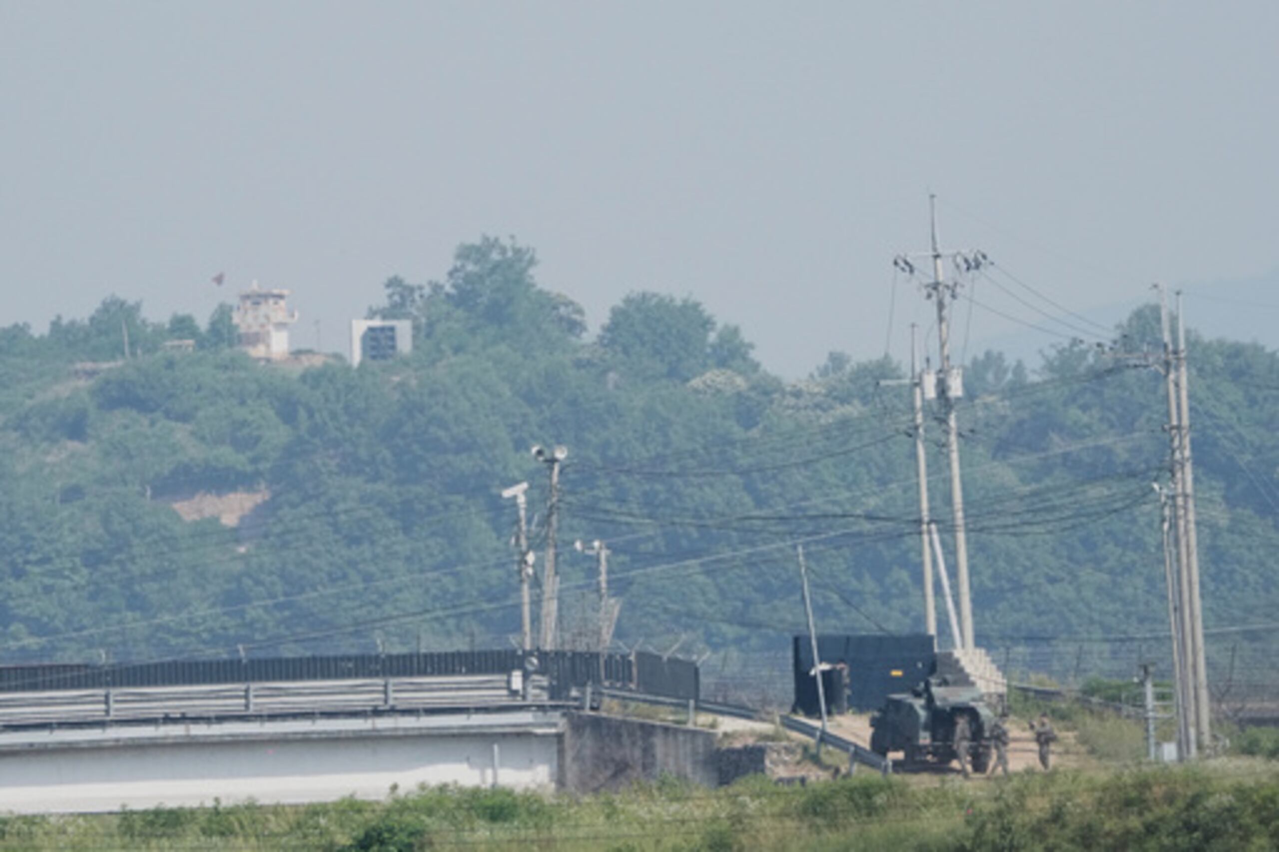 Un puesto de vigilancia norcoreano, arriba a la izquierda, y soldados surcoreanos, abajo a la derecha, pueden apreciarse en esta fotografía del 12 de junio de 2025 captada desde Paju, Corea del Sur.