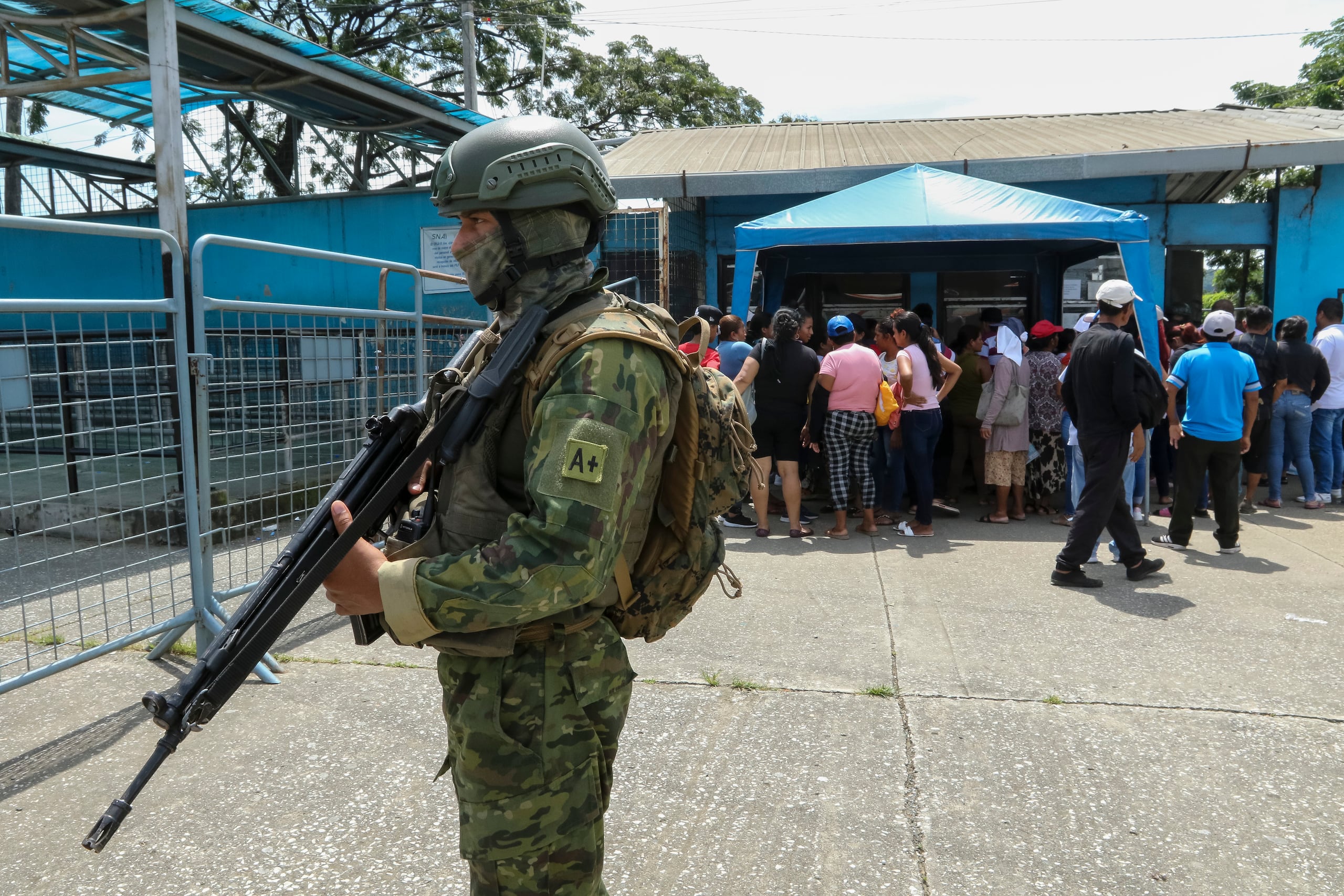 Fotografía de militares con familiares de reos que esperan información en los exteriores de la Penitenciaría del Litoral, en Guayaquil (Ecuador). (EFE/ Jhonatan Miranda)
