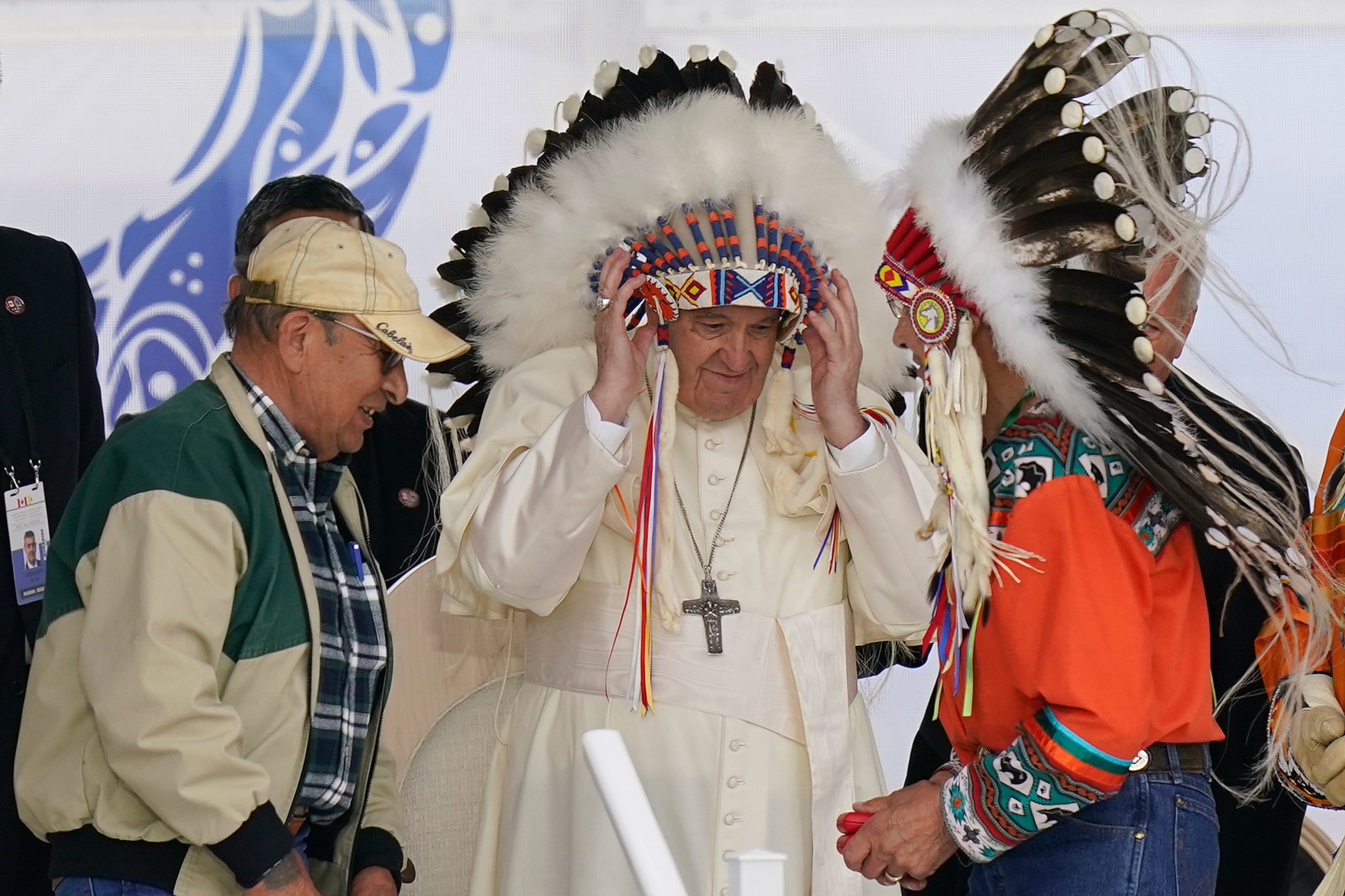 El papa Francisco se pone un penacho durante una visita a los pueblos indígenas de Maskwaci, la antigua escuela residencial Ermineskin, el lunes 25 de julio de 2022, en Maskwacis, Alberta. (AP Foto/Eric Gay/Archivo)