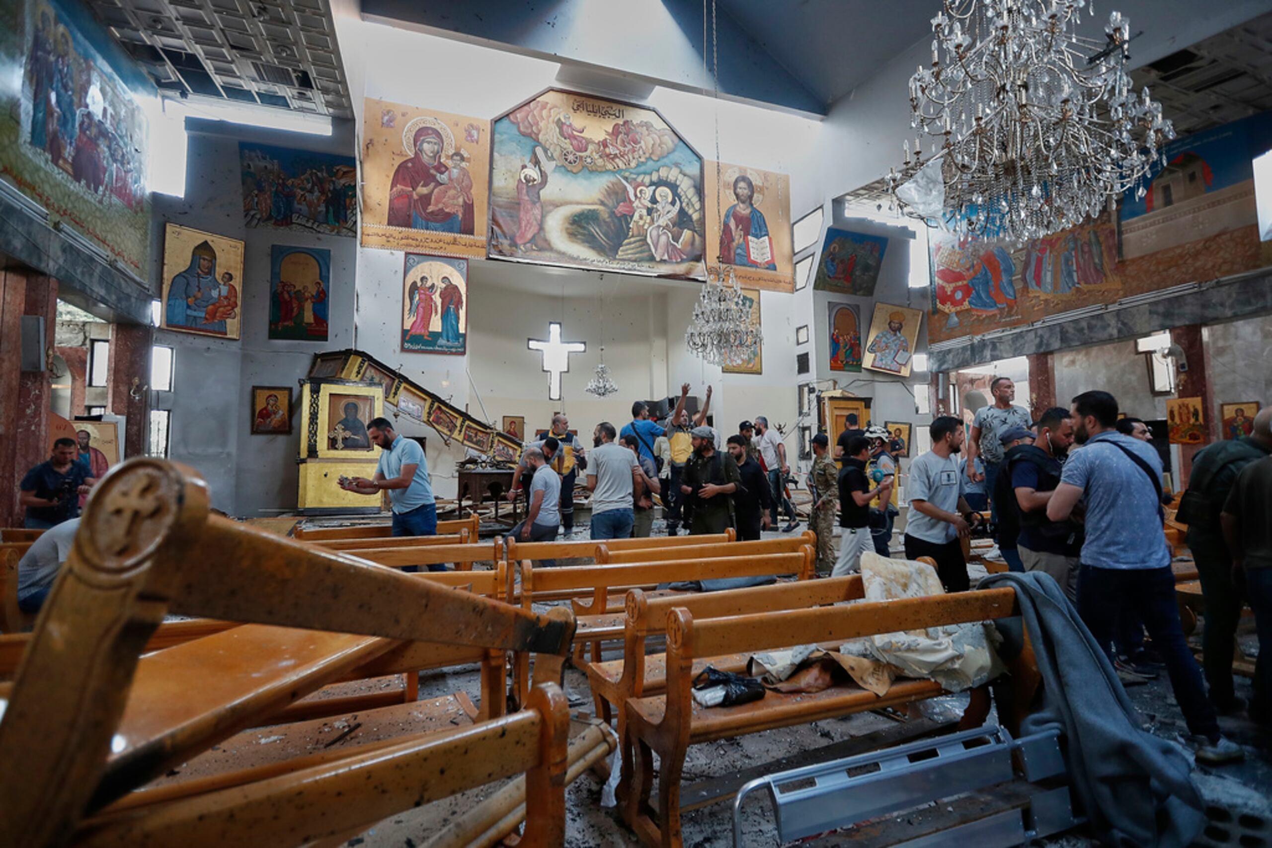 Ciudadanos sirios y fuerzas de seguridad inspeccionan los daños dentro de la iglesia Mar Elías, donde un atacante suicida se hizo estallar en Dweil'a, en las afueras de Damasco, Siria, el domingo 22 de junio de 2025.