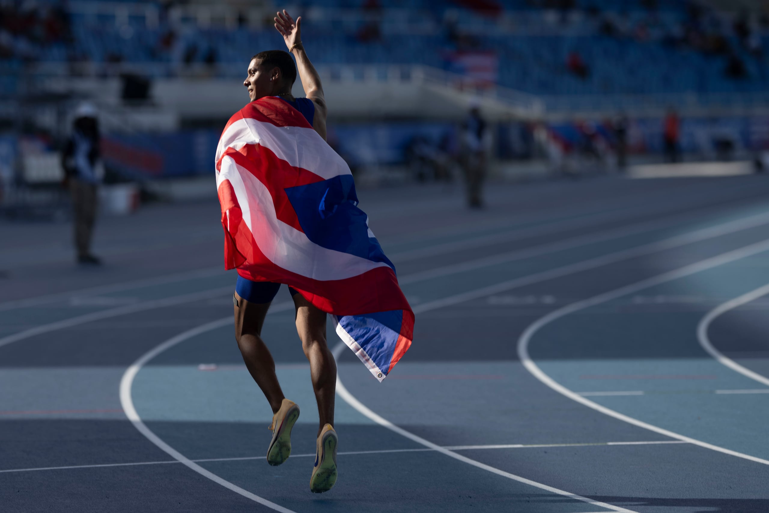 José Figueroa se arropa con la bandera de Puerto Rico tras concluir la final de los 200 metros de los Juegos Centroamericanos y del Caribe.