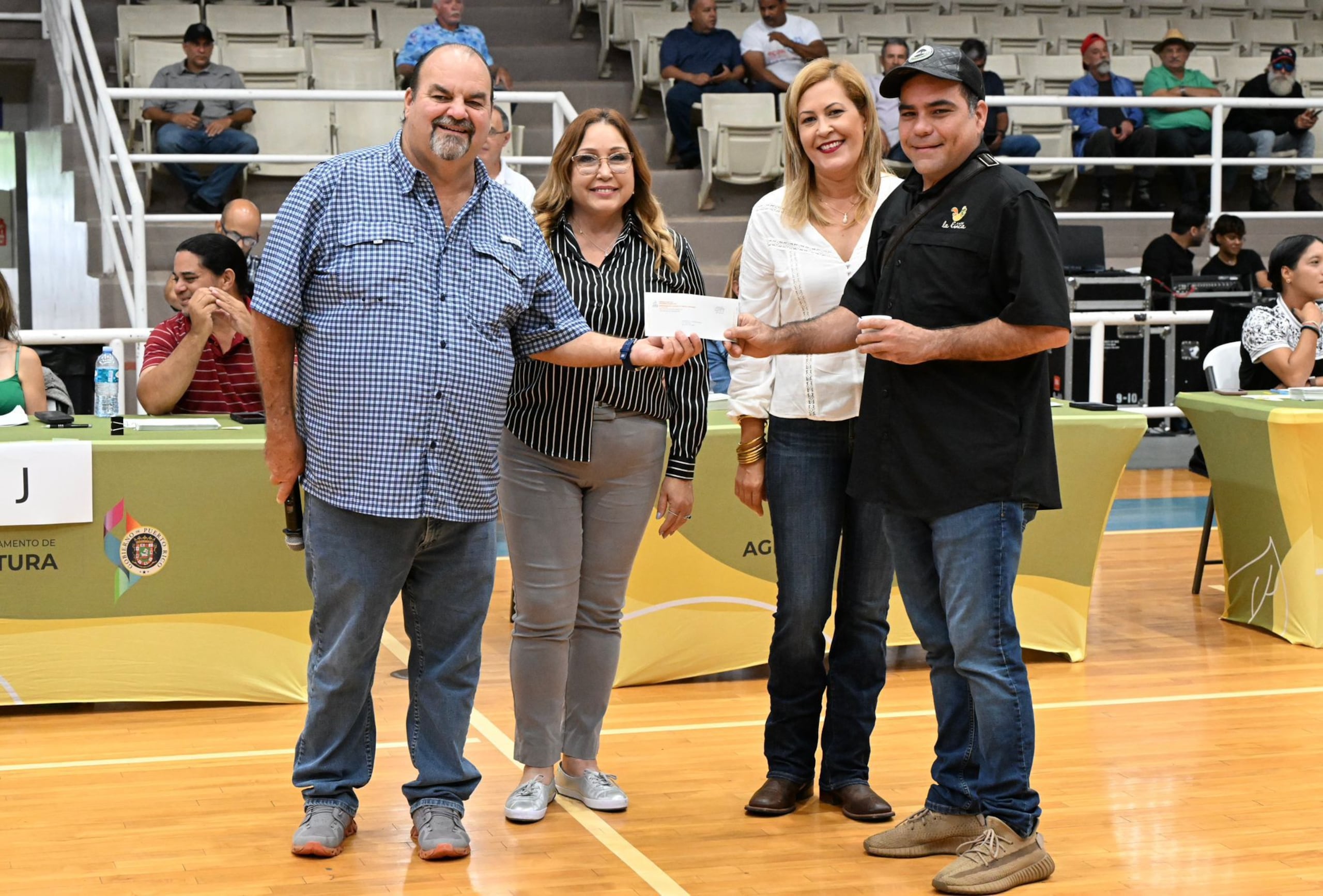 El secretario de Agricultura, Ramón González Beiró, le entrega a un agricultor su cheque del incentivo que se reparte tras el paso de la tormenta Ernesto.