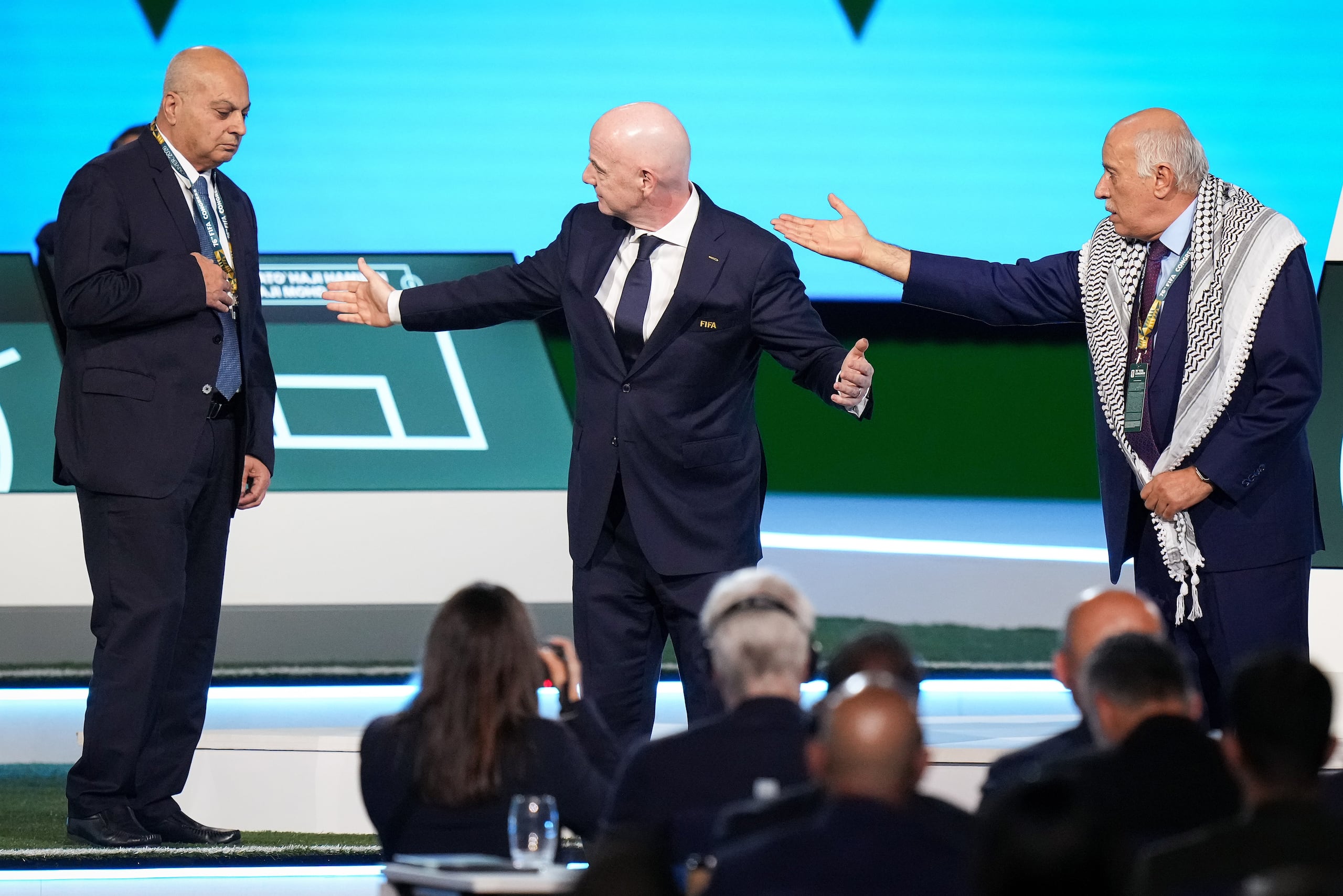 El presidente de la Asociación de Fútbol Palestina Jibril Rajoub se rehúsa a darle la mano al presidente de la Asociación de Fútbol de Israel Basim Sheikh Suliman junto al presidente de la FIFA President Gianni Infantino durante el 76mo Congreso de la FIFA el jueves 30 de abril del 2026. (Darryl Dyck/The Canadian Press via AP)