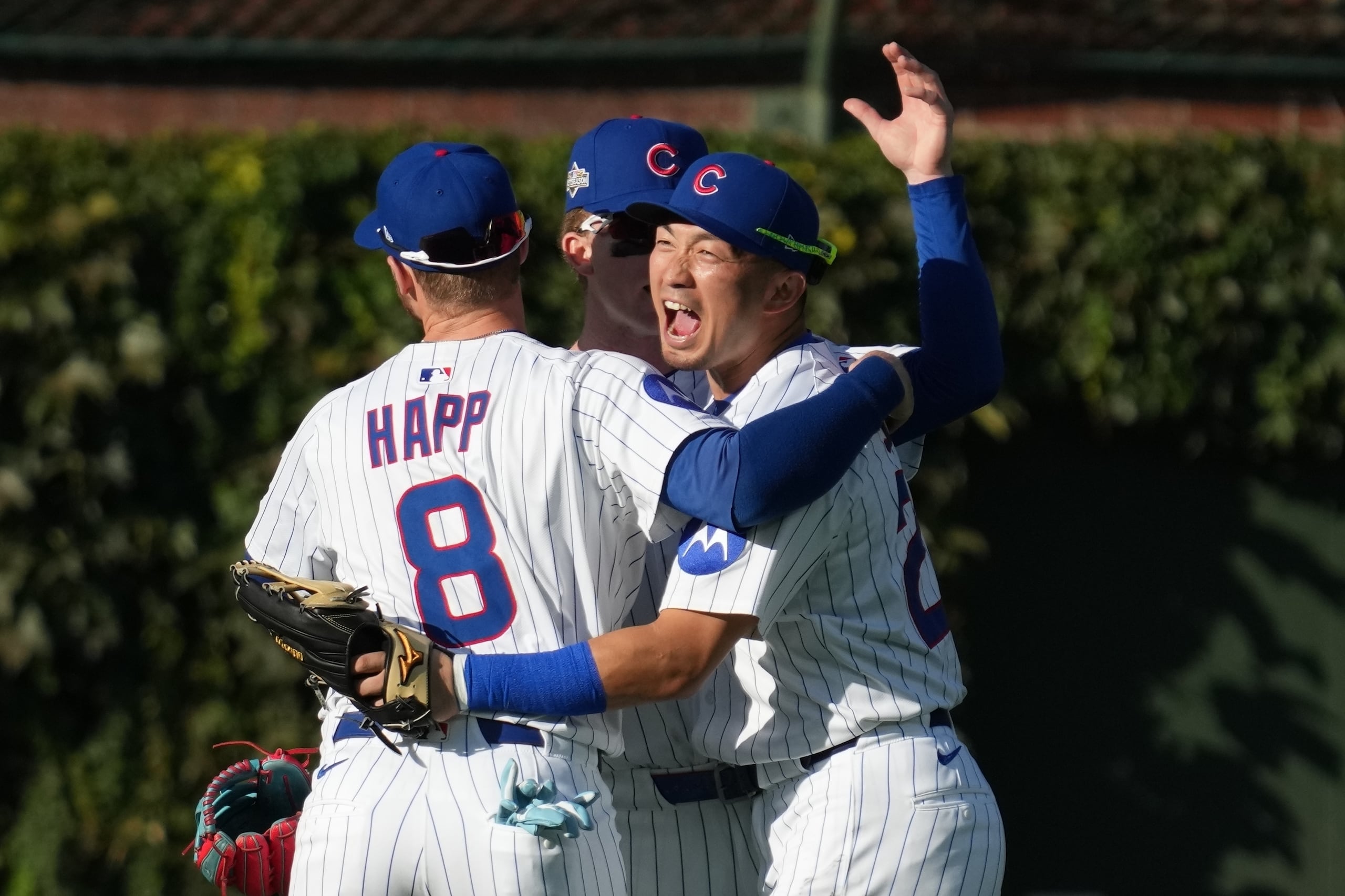 Seiya Suzuki, Pete Crow-Armstrong e Ian Happ se abrazan para celebrar el triunfo de los Cubs de Chicago.