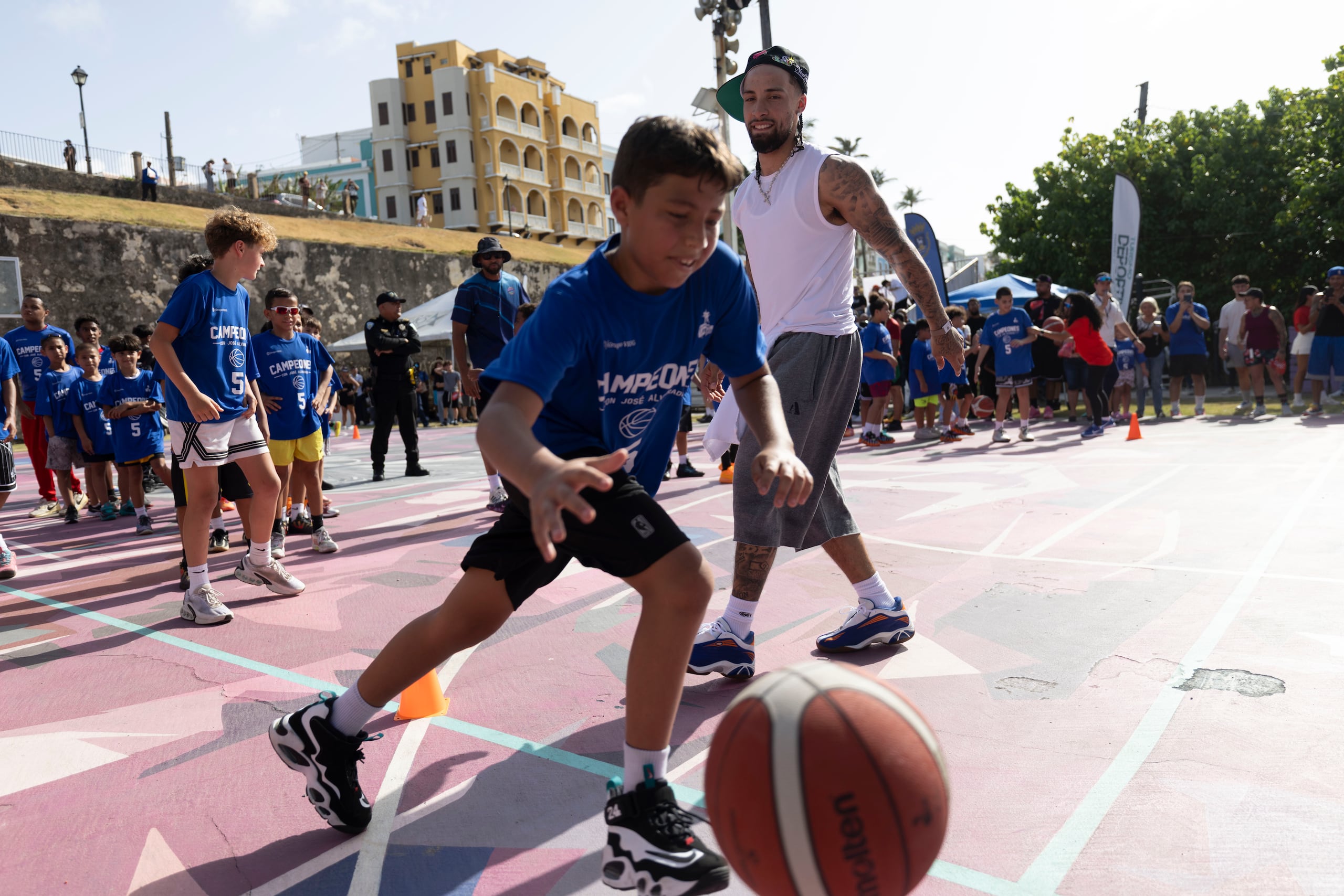 José Alvarado junto a uno de los niños que asistió a su clínica de baloncesto en La Perla.