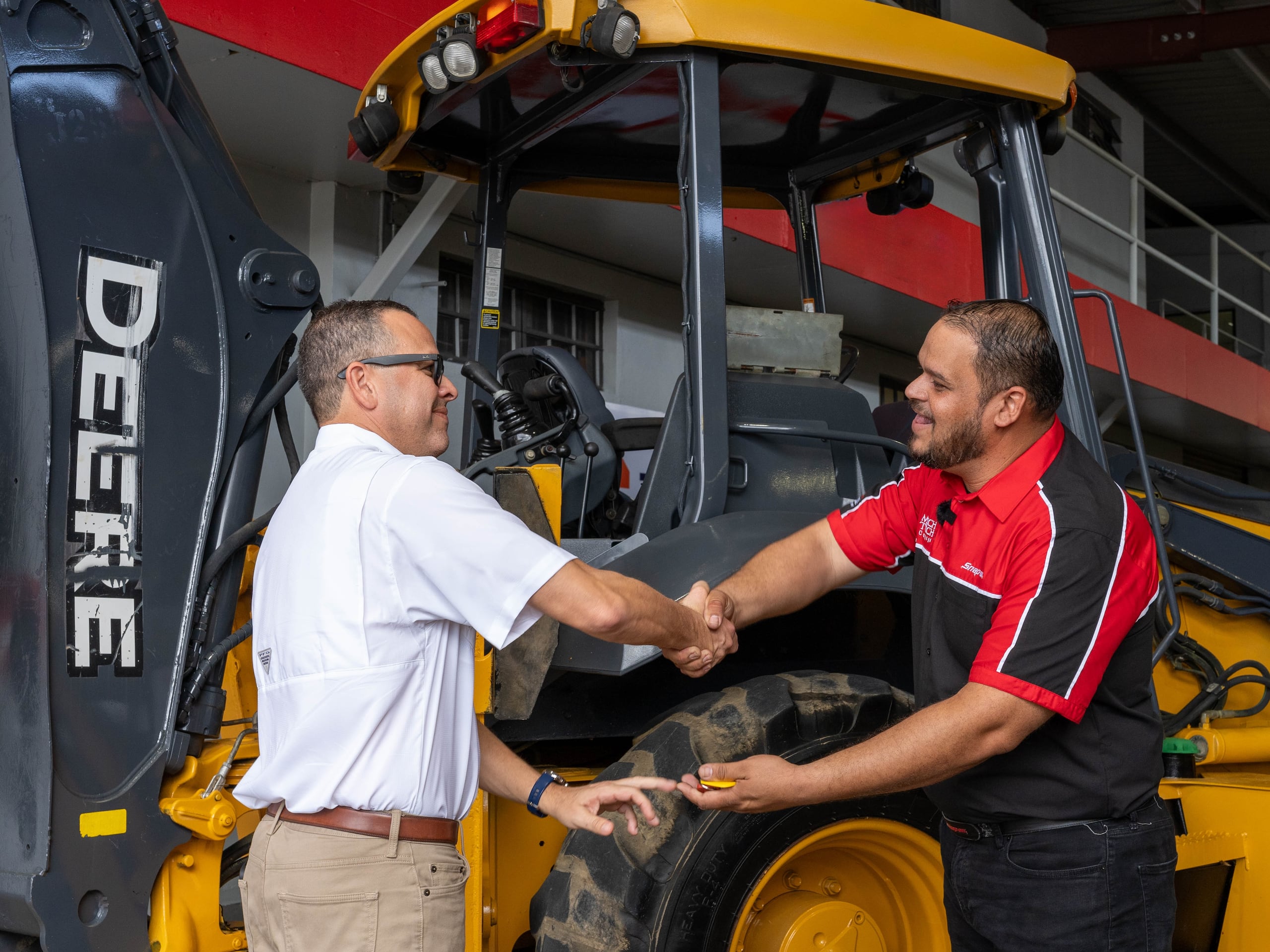 Francisco Brigantty, principal oficial de operaciones de Teselta, entrega las llaves de un equipo John Deere a Mech-Tech.