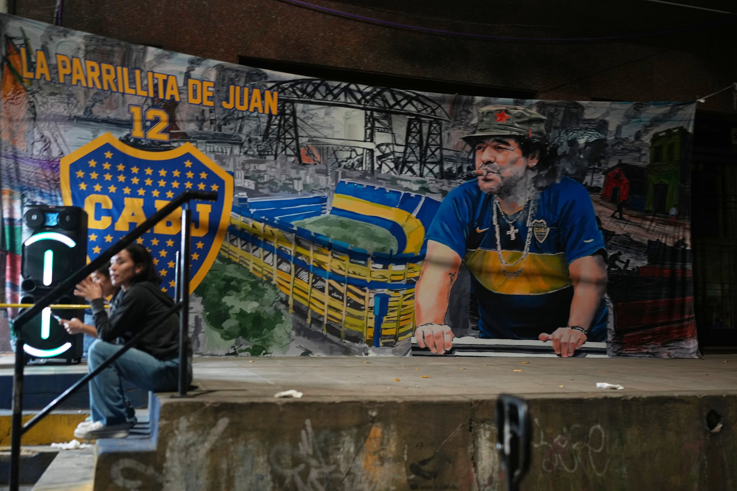 Un póster de la leyenda del fútbol Diego Maradona cuelga en las afueras del estadio La Bombonera en Buenos Aires.