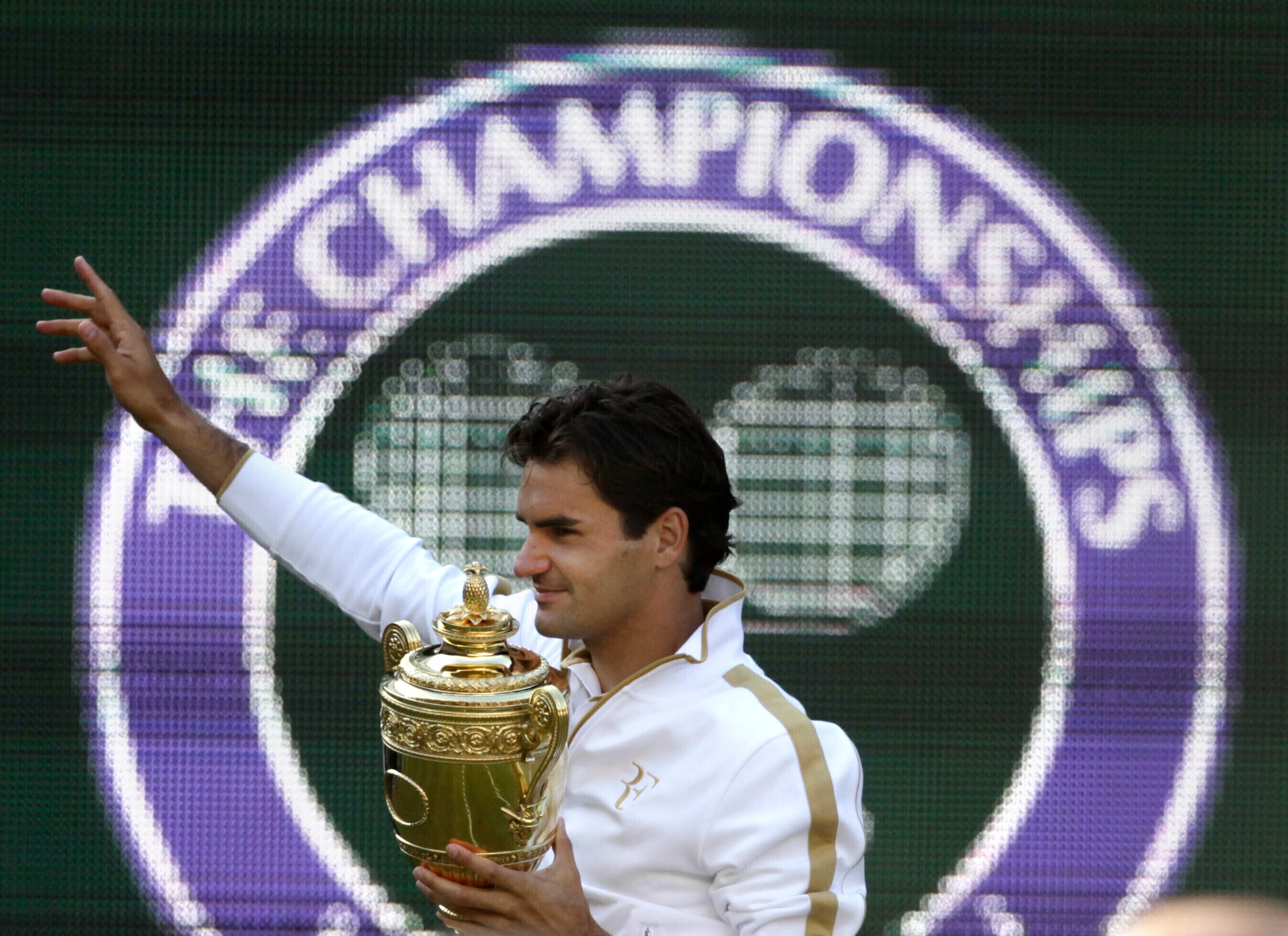 ARCHIVO - Roger Federer sostiene el trofeo de campeón de Wimbledon tras vencer a Andy Roddick en la final masculina, el 5 de julio de 2009. (AP Foto/Anja Niedringhaus)