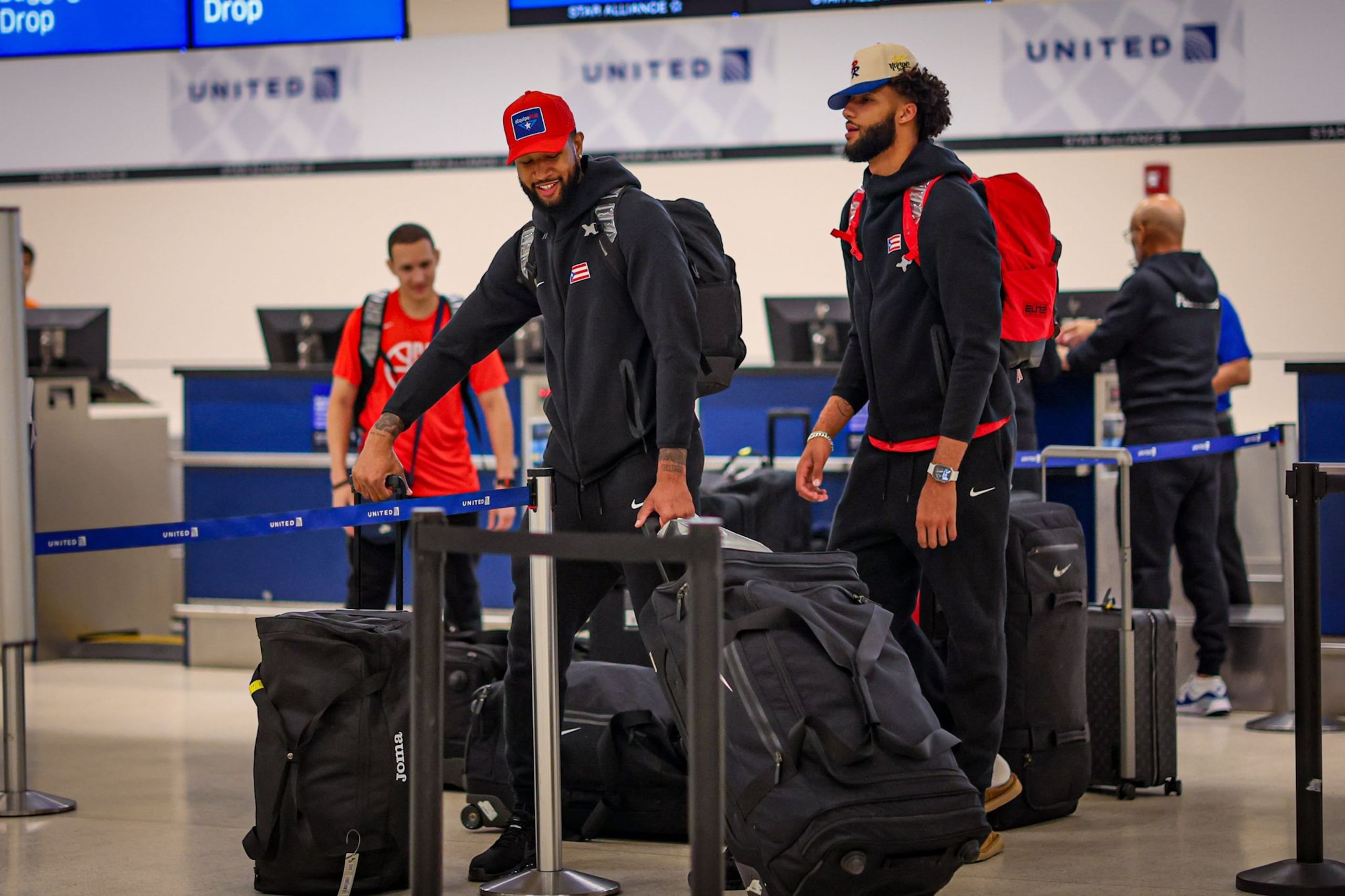 Chris Ortiz y George Conditt IV mueven el equipaje para el viaje con destino a París 2024 y paradas en Grecia, Francia y España.