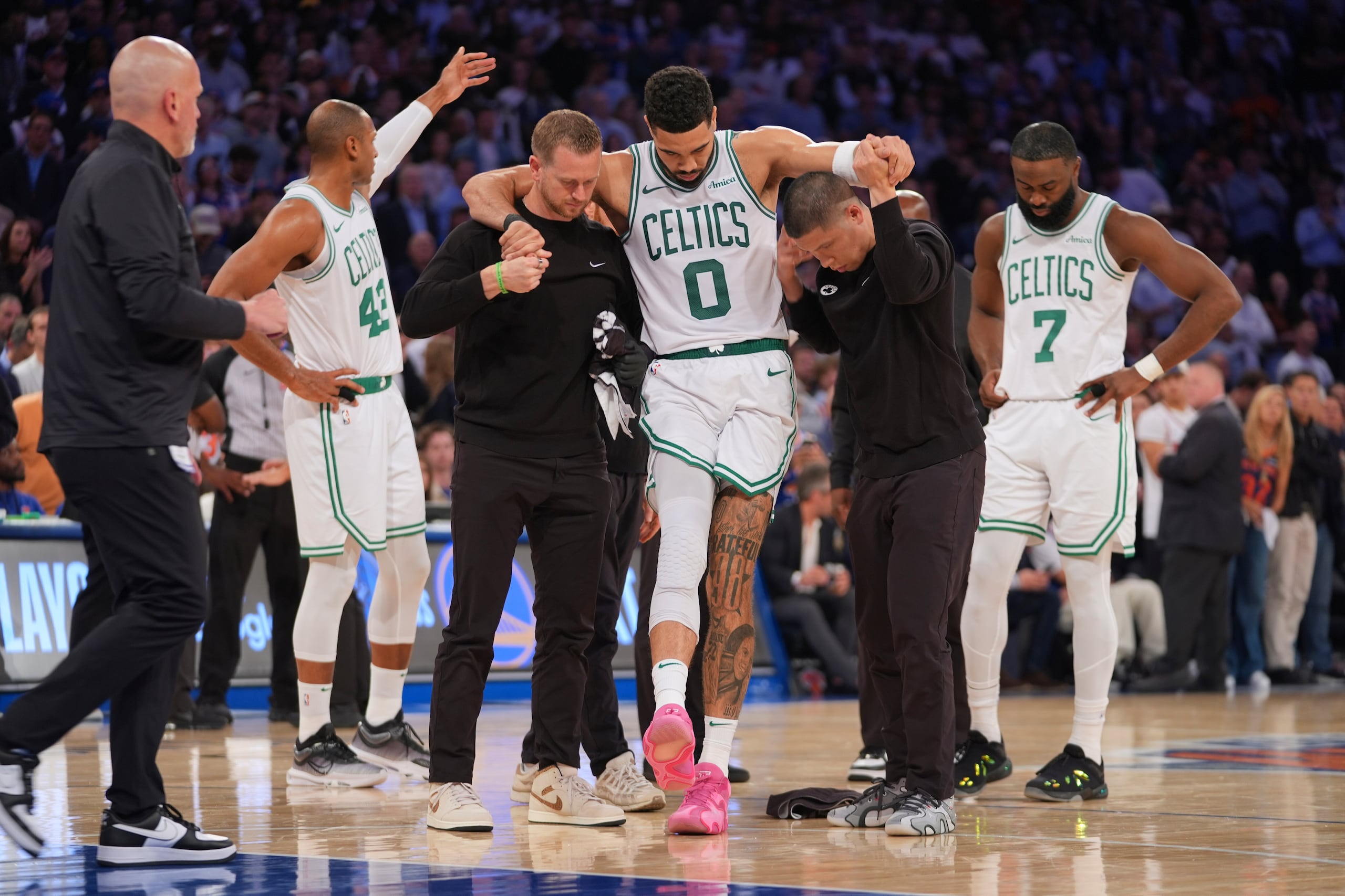 Los entrenadores ayudan a Jayson Tatum, de los Celtics de Boston, para salir de la cancha al lesionarse en el cuarto juego de las semifinales de la Conferencia Este ante los Knicks de Nueva York el lunes 12 de mayo del 2025. (AP Foto/Frank Franklin II)