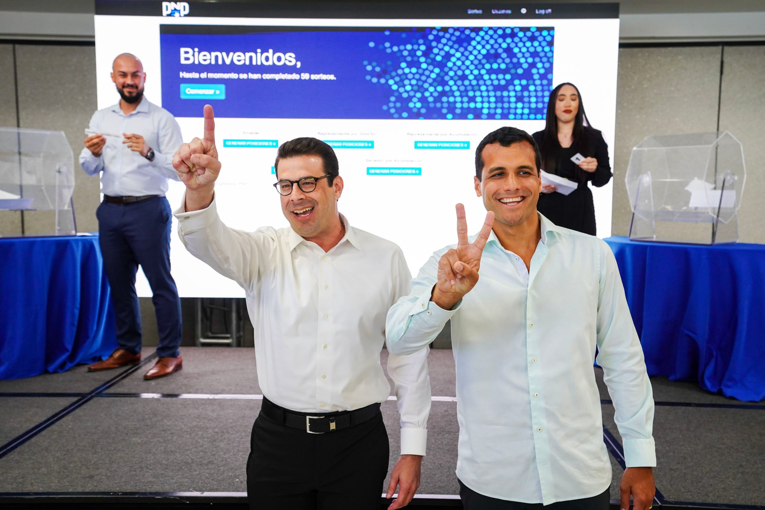Francisco Domenech, director de campaña de Jenniffer González, y Michael Pierlusi, hijo del gobernador Pedro Pierluisi y Exsecretario del Departamento de Asuntos del Consumidor, celebran tras el sorteo de las posiciones de la carrera para la gobernación en la primaria del PNP.