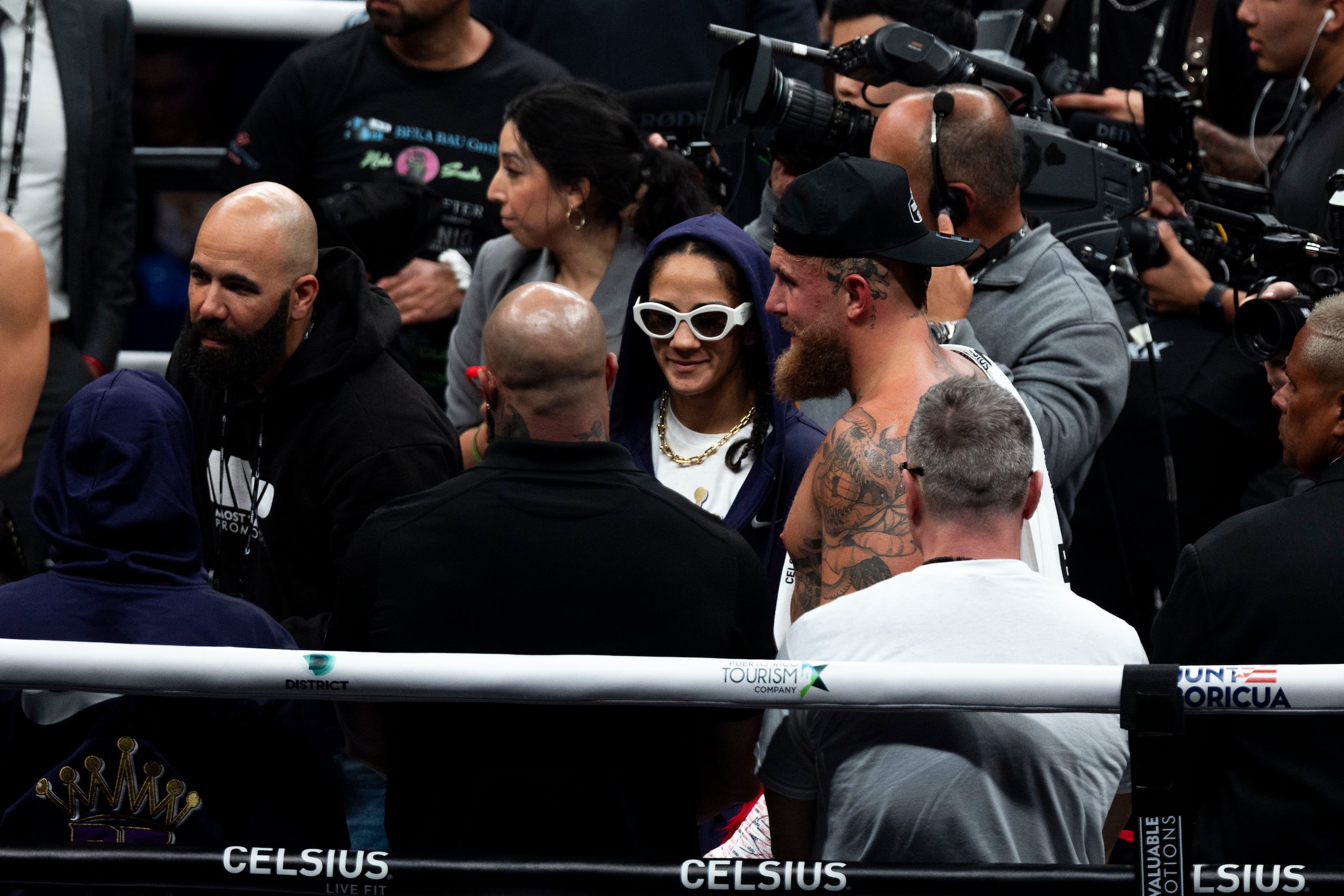 Amanda Serrano, con gafas oscuras, luce decepcionada tras anunciar al público que no podría pelear contra Nina Meinka tras sufrir una lesión en un ojo.
