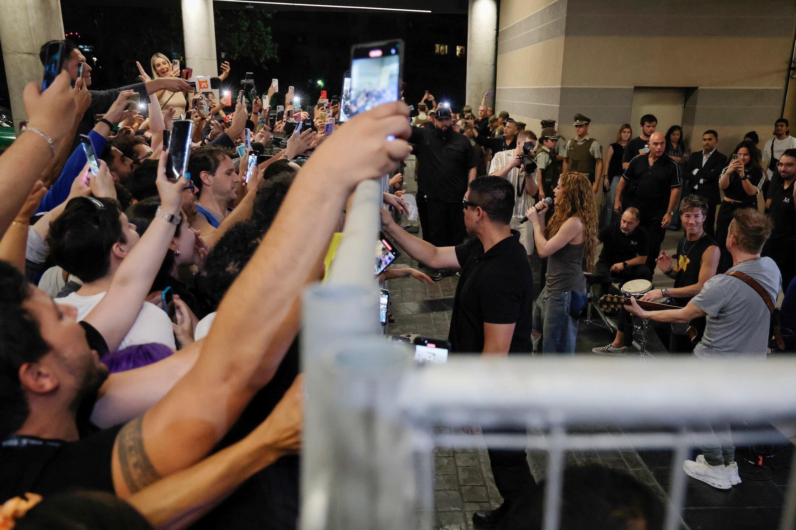 La cantante colombiana Shakira (d) canta a sus seguidores frente al Hotel Mandarin, donde se alojaba tras la cancelación de sus dos conciertos en Chile, minutos antes de partir hacia el aeropuerto este lunes, en Santiago (Chile). EFE/Javier Torres