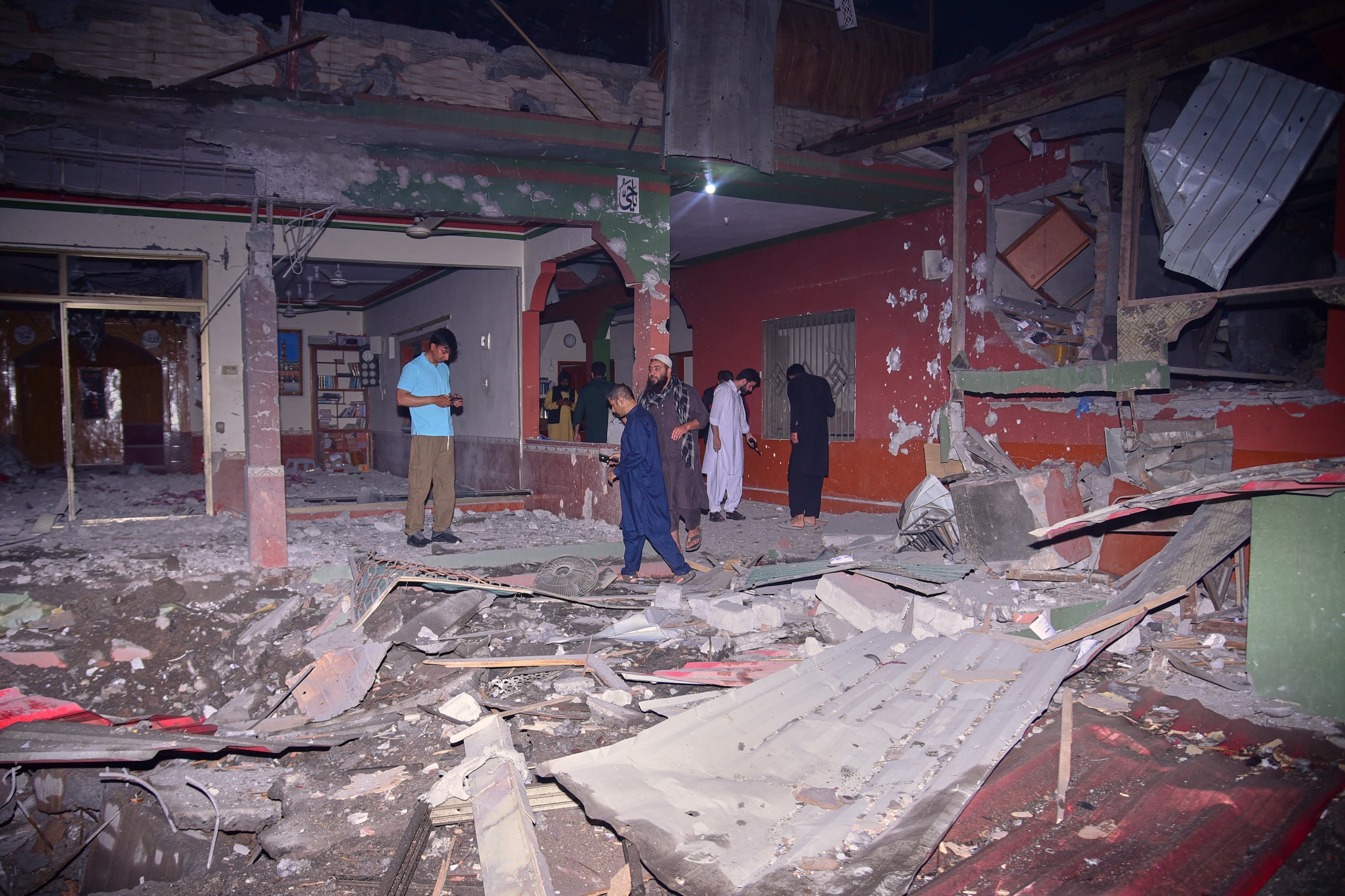 Habitantes y miembros de la prensa examinan un edificio dañado por un presunto ataque de India con misiles cerca de Muzaffarabad, la capital de la Cachemira controlada por Pakistán, el miércoles 7 de mayo de 2025. (AP Foto/M.D. Mughal)