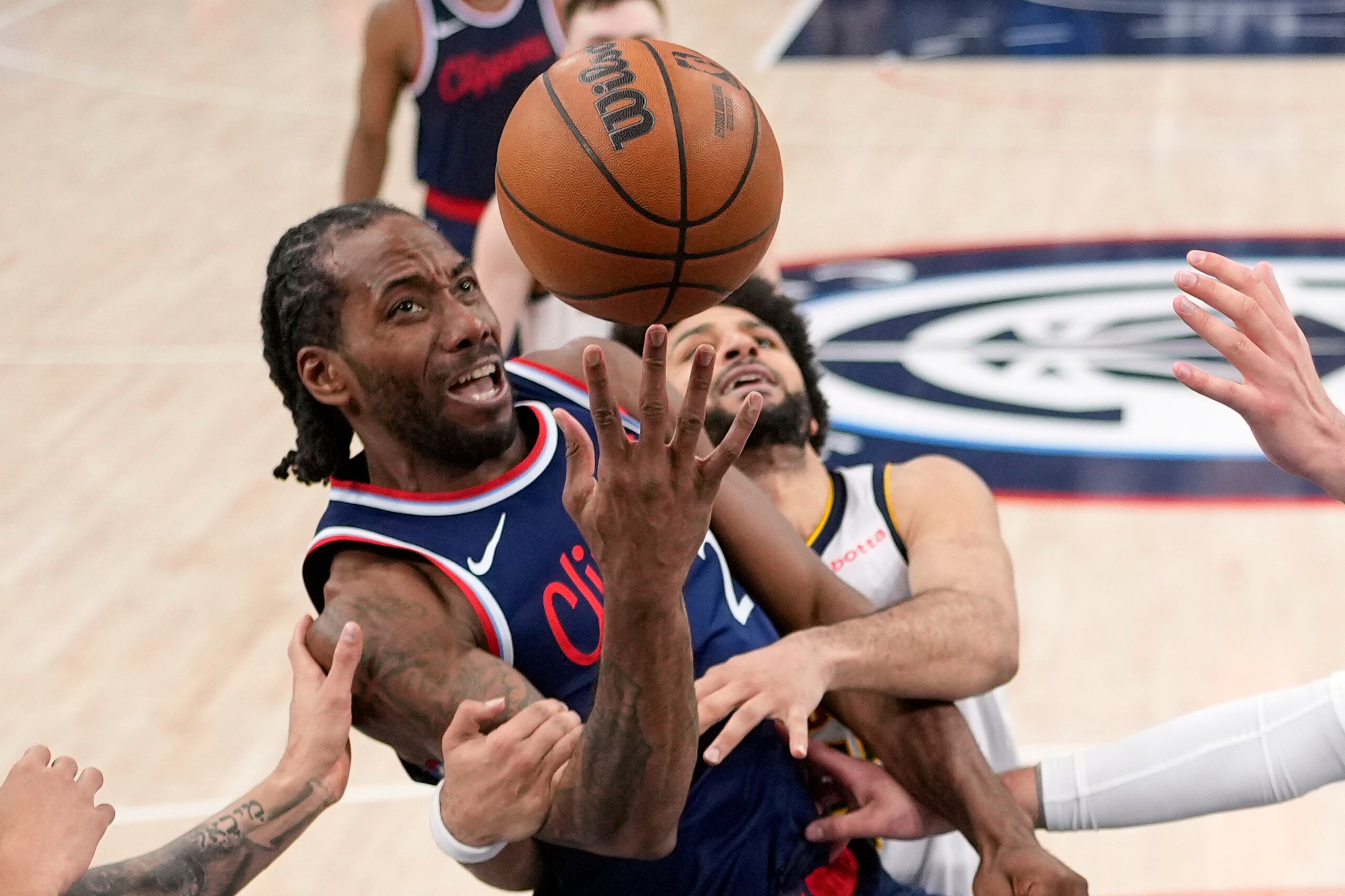 Kawhi Leonard, de los Clippers de Los Ángeles, lanza al canasto ante la defensa de Jamal Murray, de los Nuggets de Denver.