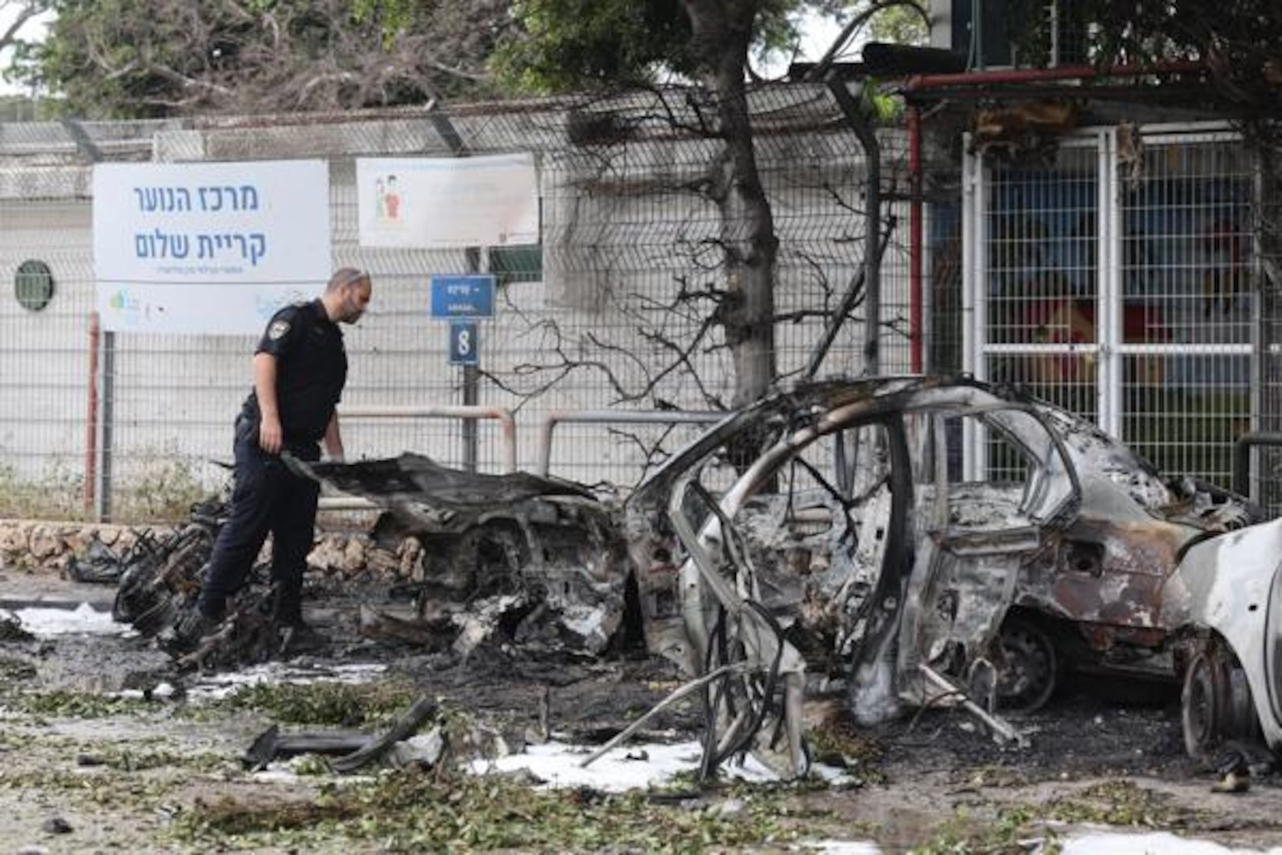 Un policía israelí inspecciona coches calcinados tras el impacto de fragmentos de un misil balístico iraní interceptado en Tel Aviv, Israel, el 15 de marzo de 2026. EFE/EPA/ABIR SULTAN