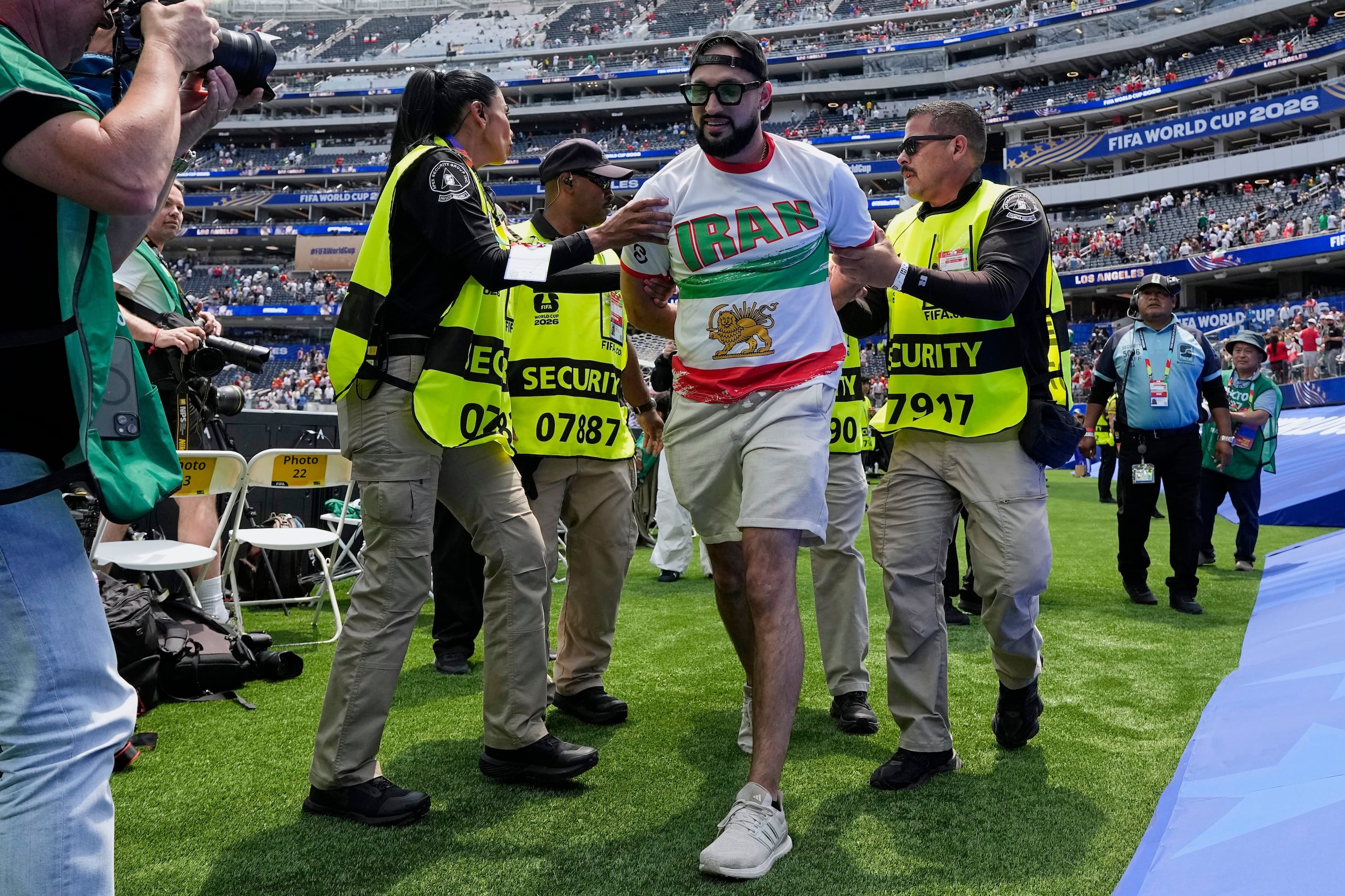 Un aficionado iraní es retirado de la cancha al final del encuentro del Mundial entre la selección de su país y Bélgica.
