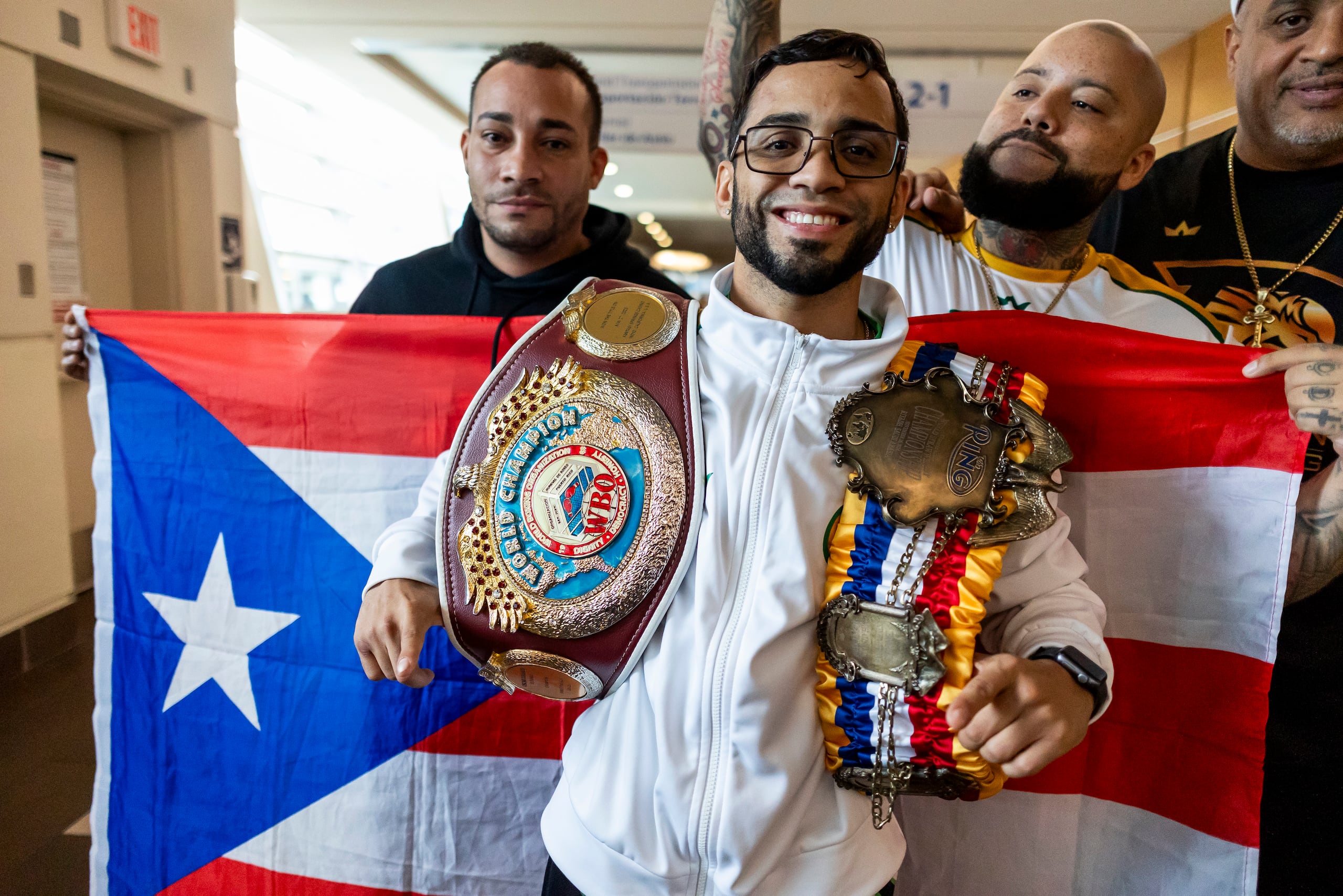 Oscar Collazo muestra aquí sus dos coronas del peso mínimo.