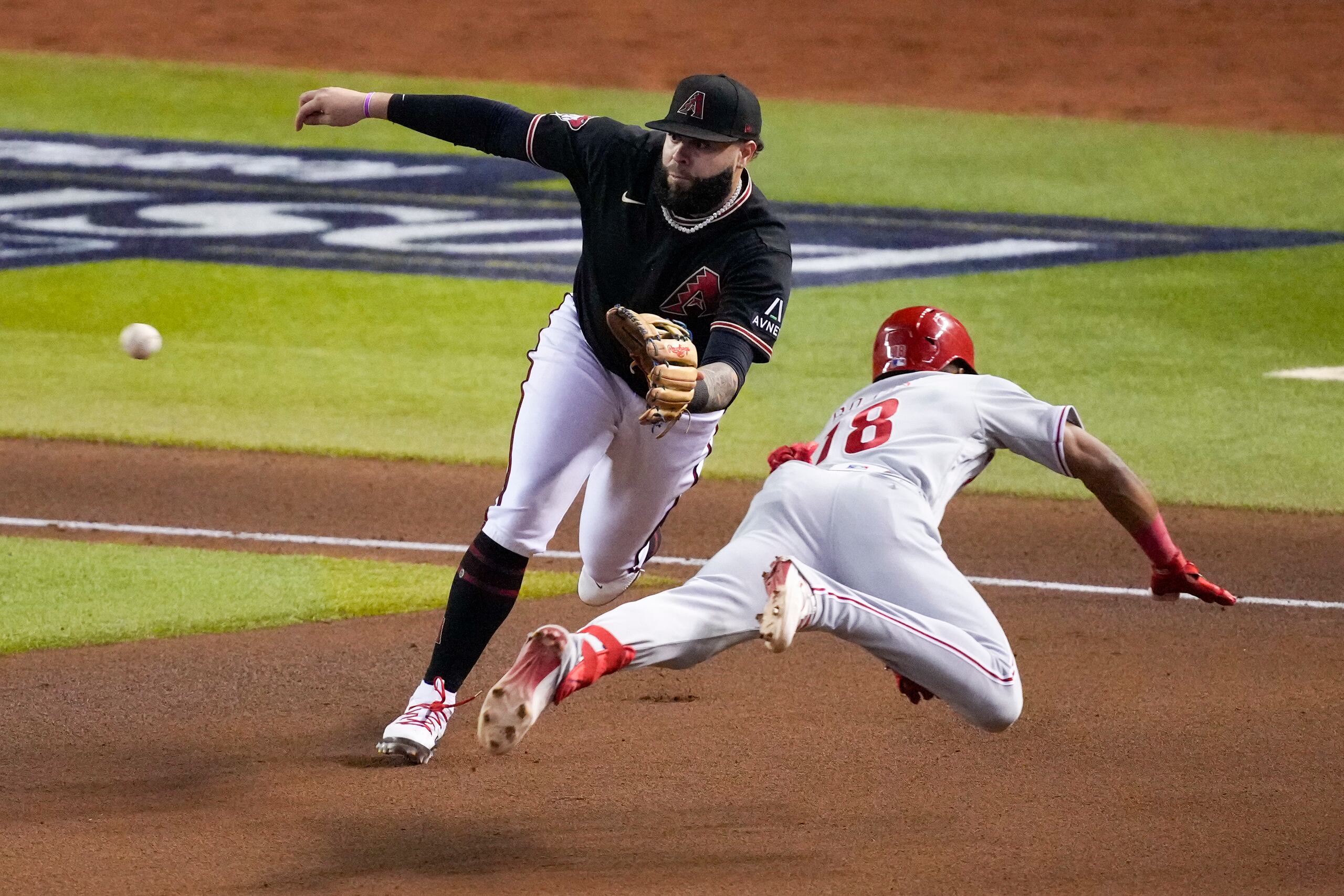 El boricua Emmanuel Rivera, de los Diamondbacks de Arizona, y John Rojas, de los Phillies de Filadelfia, durante el cuarto juego de la serie de campeonato de la Liga Nacional.