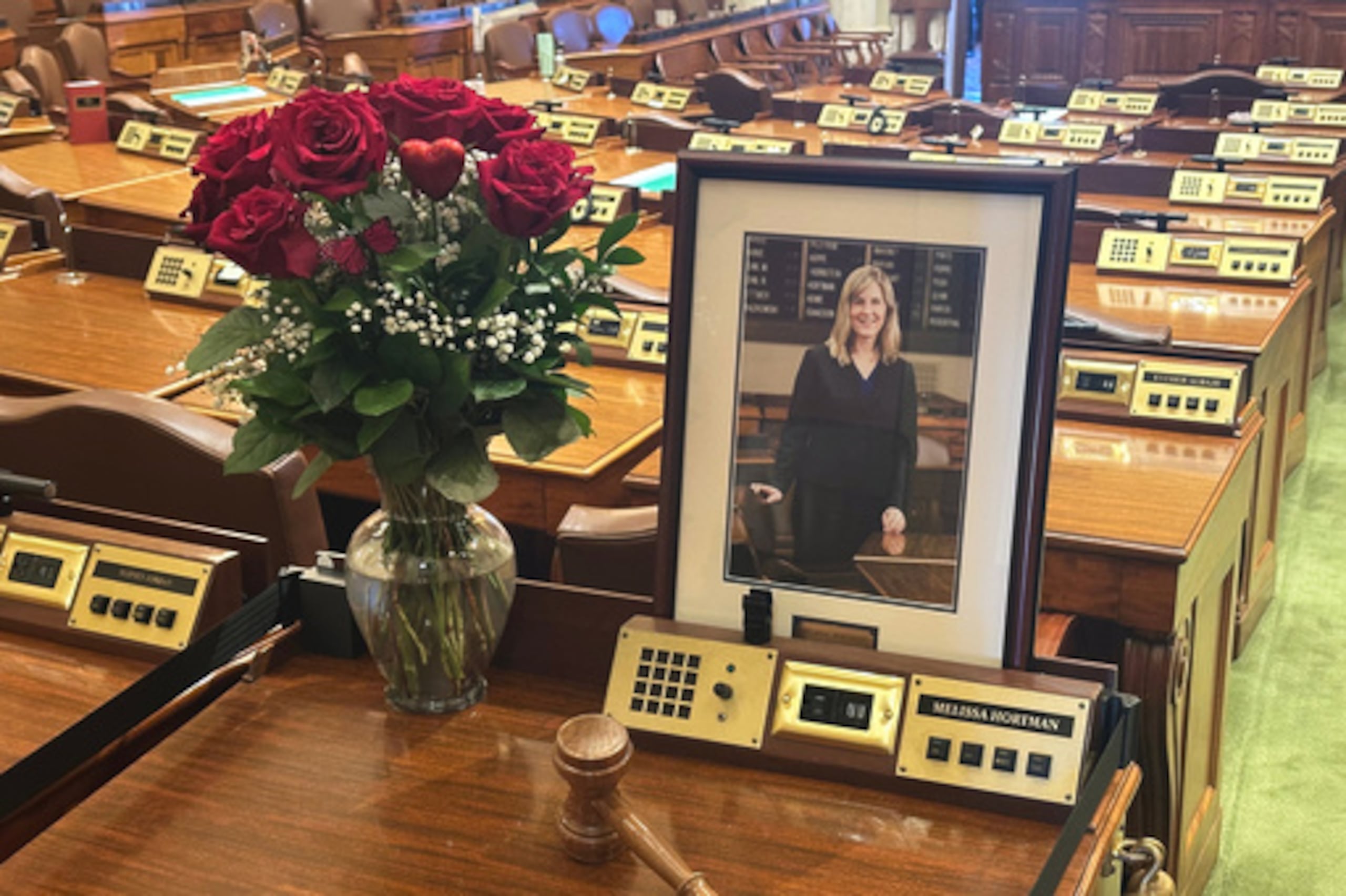 El escritorio de la difunta presidenta de la Cámara de Representantes de Minnesota, Melissa Hortman, permanece vacío en memoria de la legisladora, con excepción de flores, su retrato y un mazo, en la Cámara de Representantes del estado, el miércoles 18 de marzo de 2026, en el Capitolio del estado, en St. Paul, Minnesota.