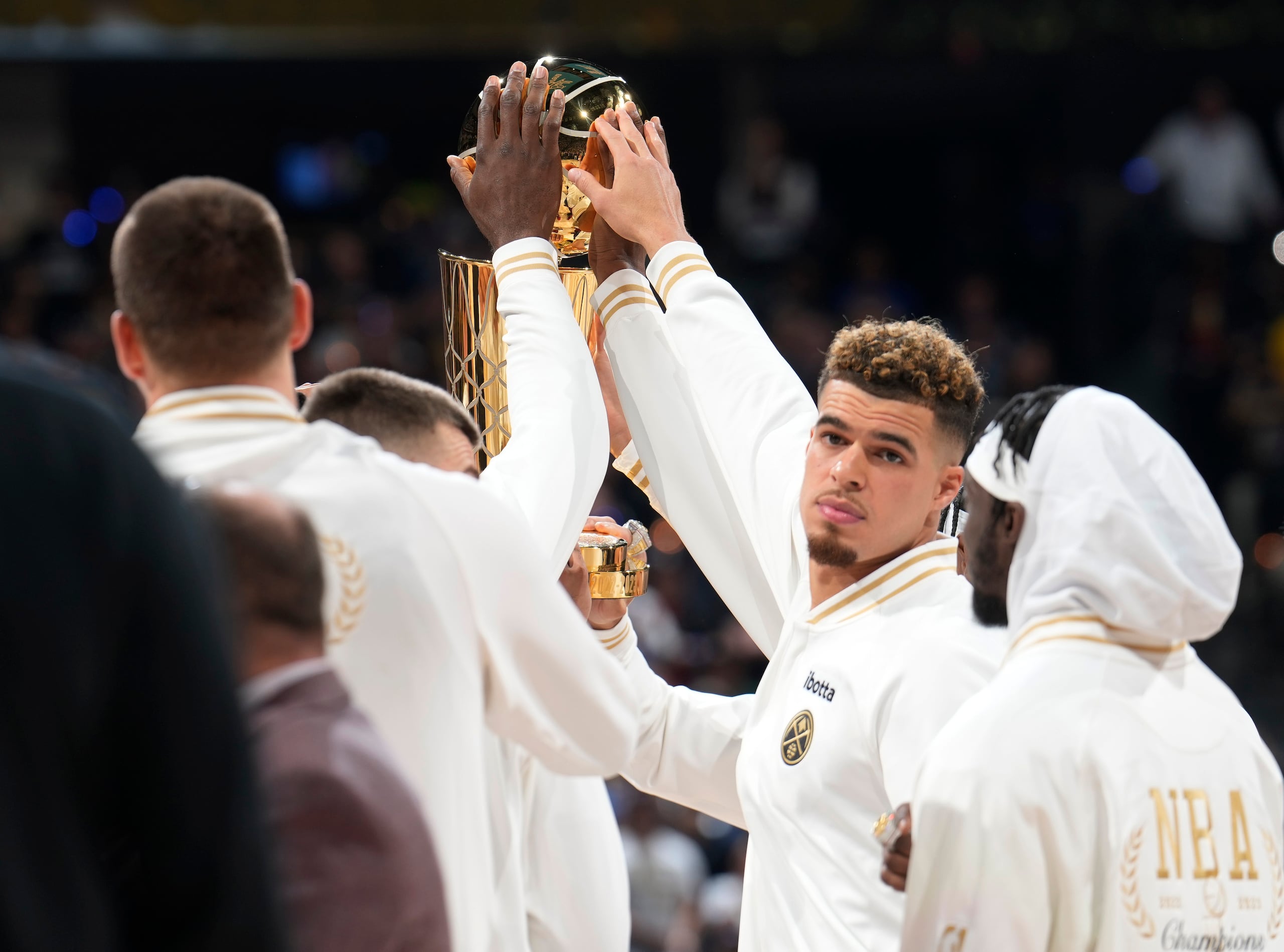 Nikola Jokic, izquierda, y el delantero Michael Porter Jr. tocan el campeonato de la NBA.